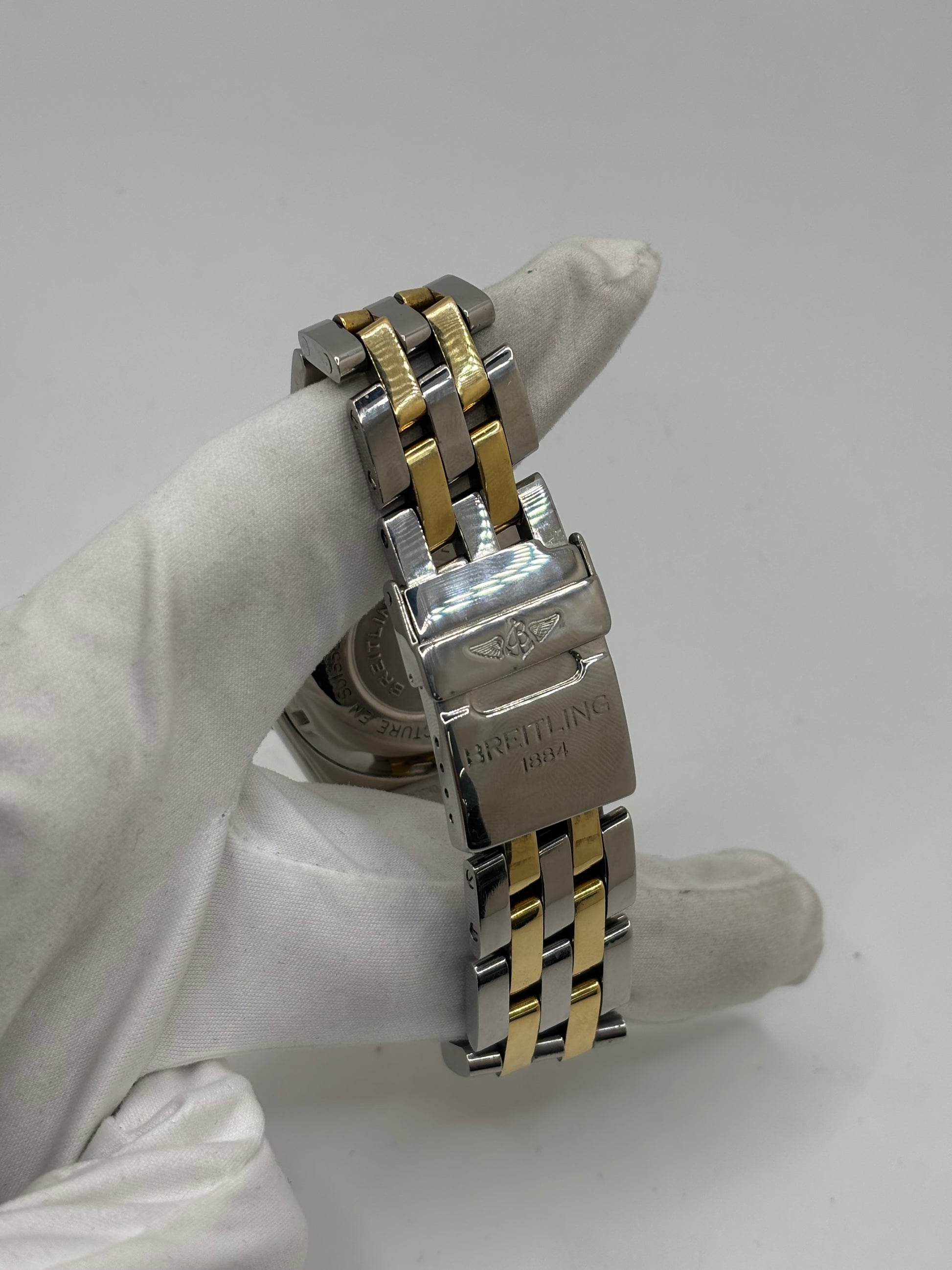 Montre Breitling Chronomat B13050.1 en or et acier avec boîtier de 39 mm, cadran blanc à chiffres arabes, verre saphir et mouvement automatique Breitling 13 basé sur l'ETA Valjoux 7750. Ce chronographe est équipé d'un bracelet en or et acier avec boucle déployante d'origine. Révisée, en excellent état et garantie 1 an, cette montre de luxe suisse allie élégance intemporelle, précision horlogère et finitions haut de gamme.