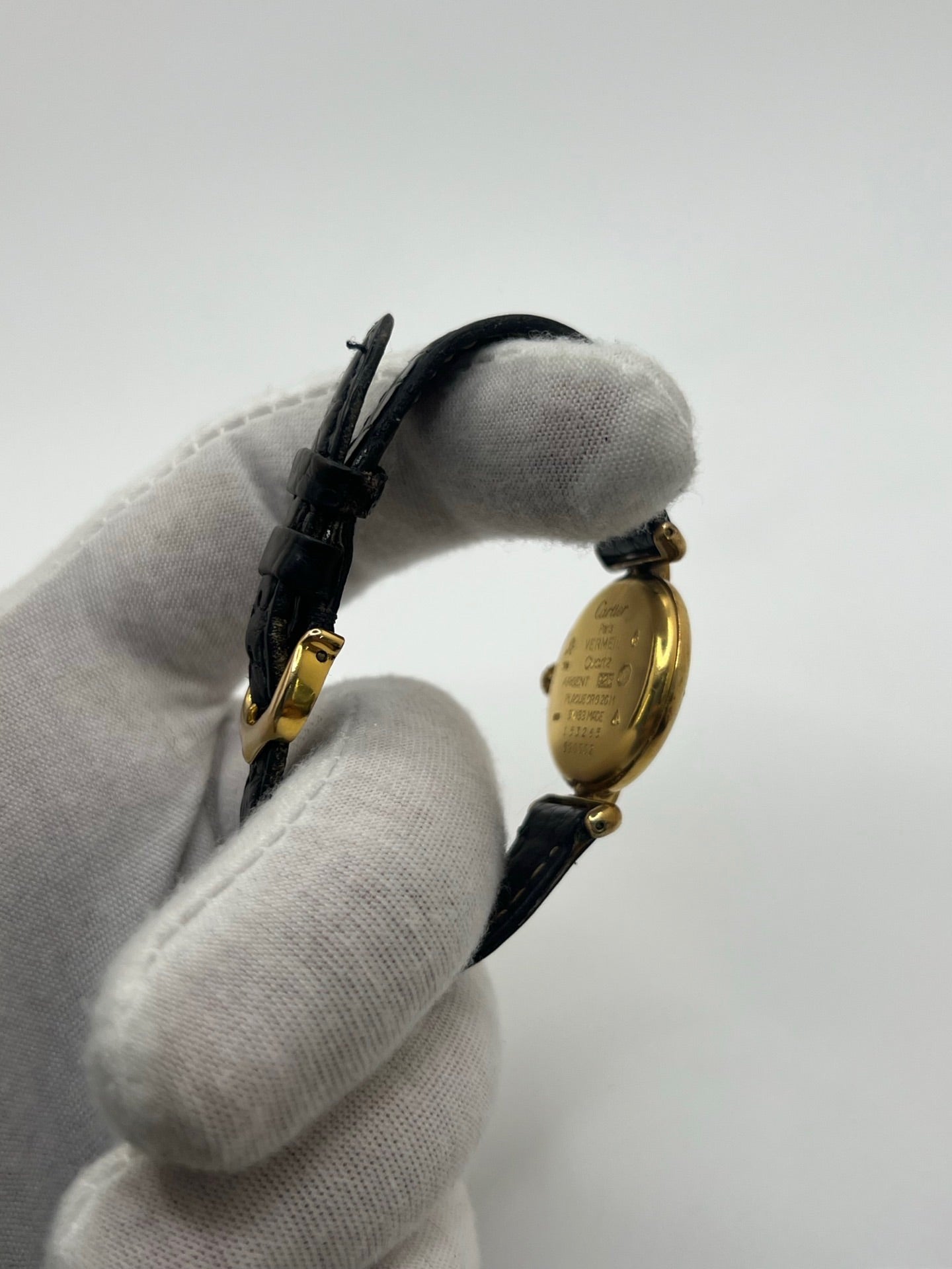 Montre Cartier Colisée Must Vermeil réf. 590002 pour femme, équipée d’un mouvement quartz précis. Boîtier en argent vermeil de 24 mm, cadran blanc à chiffres romains, verre saphir et bracelet en cuir noir avec boucle ardillon. Modèle d’occasion en bon état présentant quelques traces d’usure. Idéal pour les amateurs de montres élégantes et intemporelles.