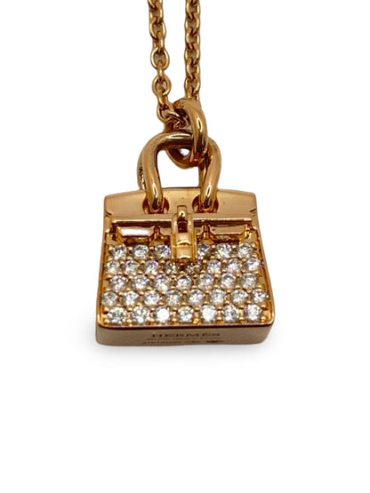 Collier Hermès Sac Birkin en or rose 18K serti de diamants totalisant 0,22 carat. Cette création joaillière raffinée s’inspire de l’iconique sac Birkin et associe l’éclat chaleureux de l’or rose 750 millièmes à la brillance délicate des diamants. Bijou de luxe élégant et féminin, idéal pour une collection de haute joaillerie, une occasion spéciale ou un cadeau précieux. Finitions soignées et design emblématique signé Hermès.
