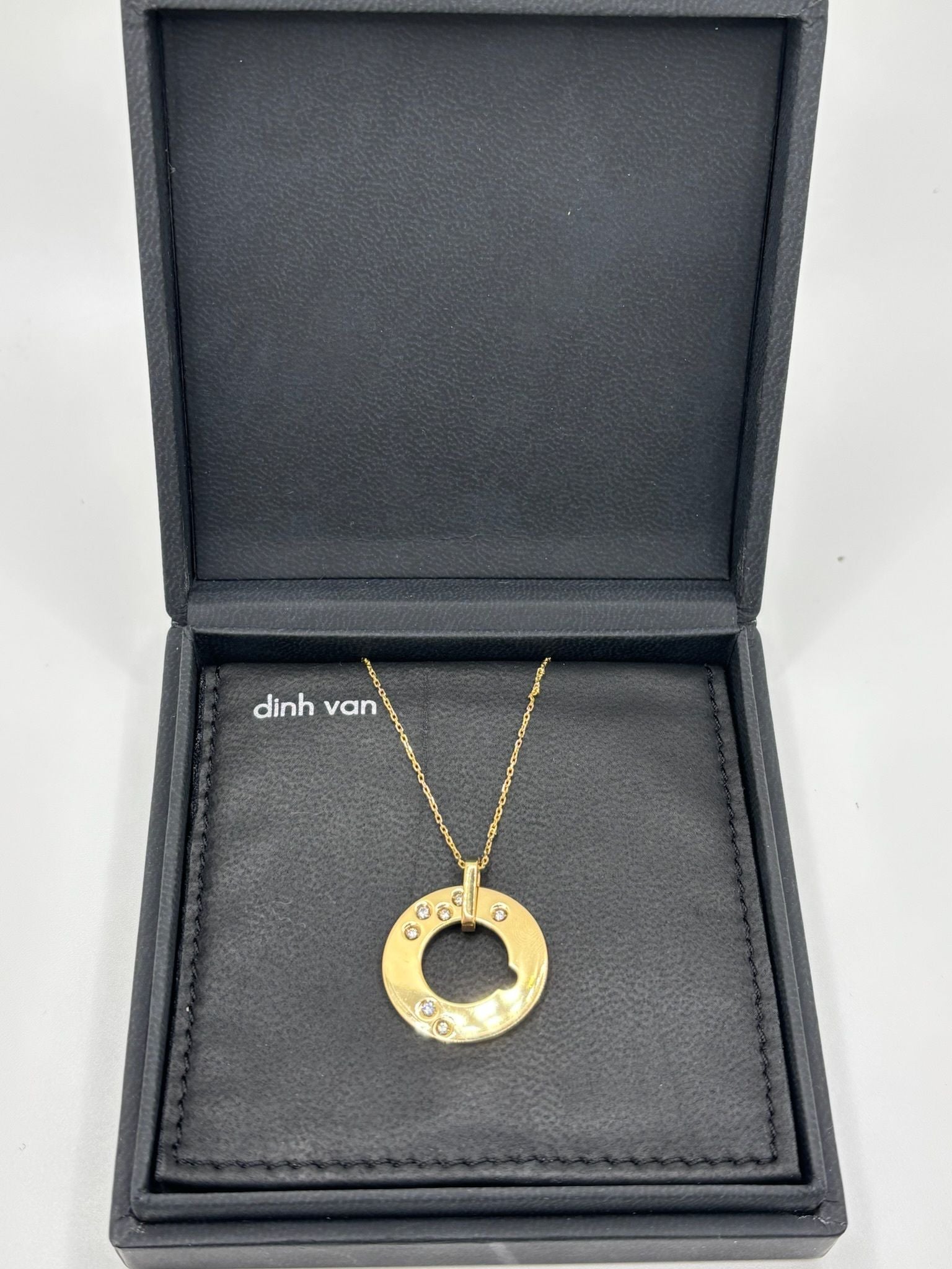 Collier Cible signé Dinh Van, en or jaune 18 carats, délicatement orné de 0,15 carat de diamants. Icône de la maison, ce modèle emblématique joue sur la géométrie et l’équilibre parfait des formes. À la fois moderne et intemporel, ce bijou capture la lumière avec finesse et symbolise une élégance discrète. Idéal à porter au quotidien ou à offrir en cadeau, il reflète tout le raffinement du design Dinh Van.