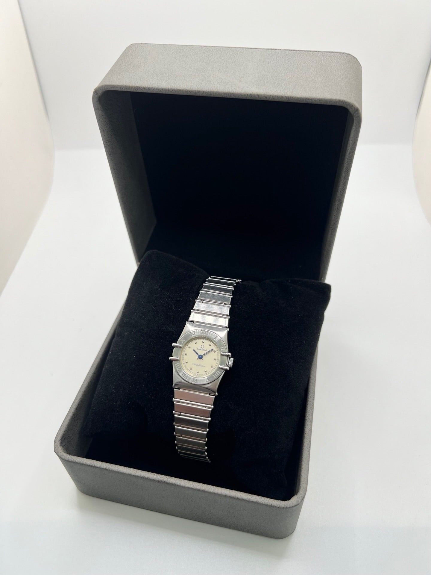 Montre Omega Constellation Quartz réf. 795.0876, modèle femme vintage en acier, mouvement quartz précis, boîtier et bracelet acier inoxydable, cadran argent massif sans chiffres, verre saphir. Dimensions 23 x 26 mm. Année 1985, état très bon avec légères traces d’usage peu visibles. Montre de luxe d’occasion, révisée en interne le 23 avril 2026. Sans boîte ni papiers d’origine, disponible à Paris. Pièce d’horlogerie suisse de collection Constellation.