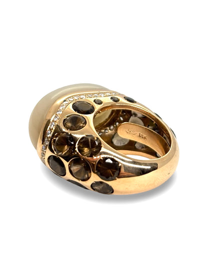 Bague Anjara en or jaune 18 carats mettant en valeur l’association harmonieuse d’une pierre de lune, d’un quartz fumé et de diamants étincelants. Ce bijou raffiné séduit par le contraste de ses gemmes, la douceur de ses reflets et son élégance intemporelle. Une création joaillière idéale pour les amateurs de pierres fines et de bijoux de caractère.
