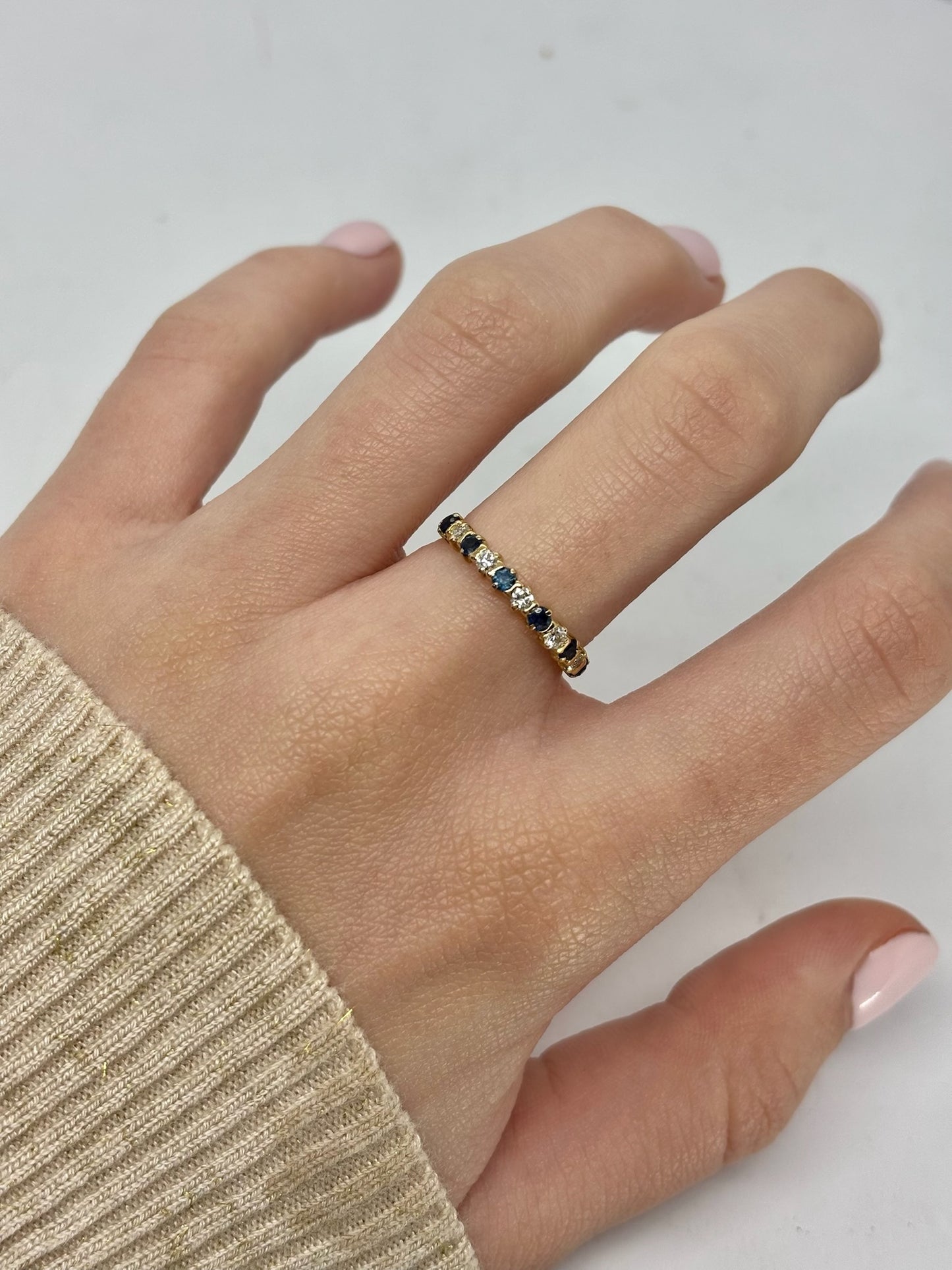 Demi-alliance en or jaune 18 carats sertie de saphirs et diamants totalisant 0,40 carat. Élégante et raffinée, cette bague demi-tour associe l’éclat profond des saphirs à la brillance des diamants pour un rendu lumineux. Idéale comme alliance, bague d’anniversaire ou bijou du quotidien, elle apporte une touche précieuse et intemporelle à chaque tenue.