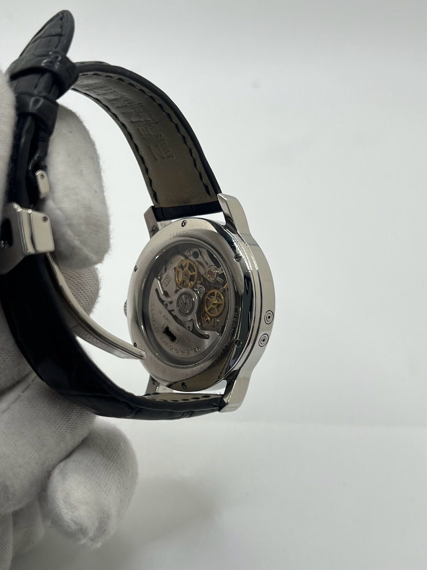 Montre chronographe automatique en acier avec cadran argenté à chiffres romains, fonction phase lunaire, date, jour et mois. Boîtier de 40 mm, verre saphir, fond transparent et bracelet en cuir noir. Modèle de haute précision doté du calibre 410 avec 50 heures de réserve de marche. Montre élégante pour homme ou unisexe.