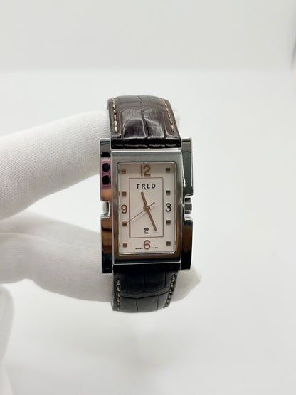 Montre Fred Tank R09-100 en excellent état, dotée d’un mouvement quartz et d’un boîtier en acier de 33 × 27 mm. Cette montre élégante présente un cadran blanc avec chiffres arabes, protégé par un verre saphir. Elle est accompagnée d’un bracelet en cuir brun avec boucle en acier. Modèle homme ou unisexe, cette Fred Tank R09-100 séduit par son design classique et intemporel, idéal pour compléter une tenue élégante au quotidien.

