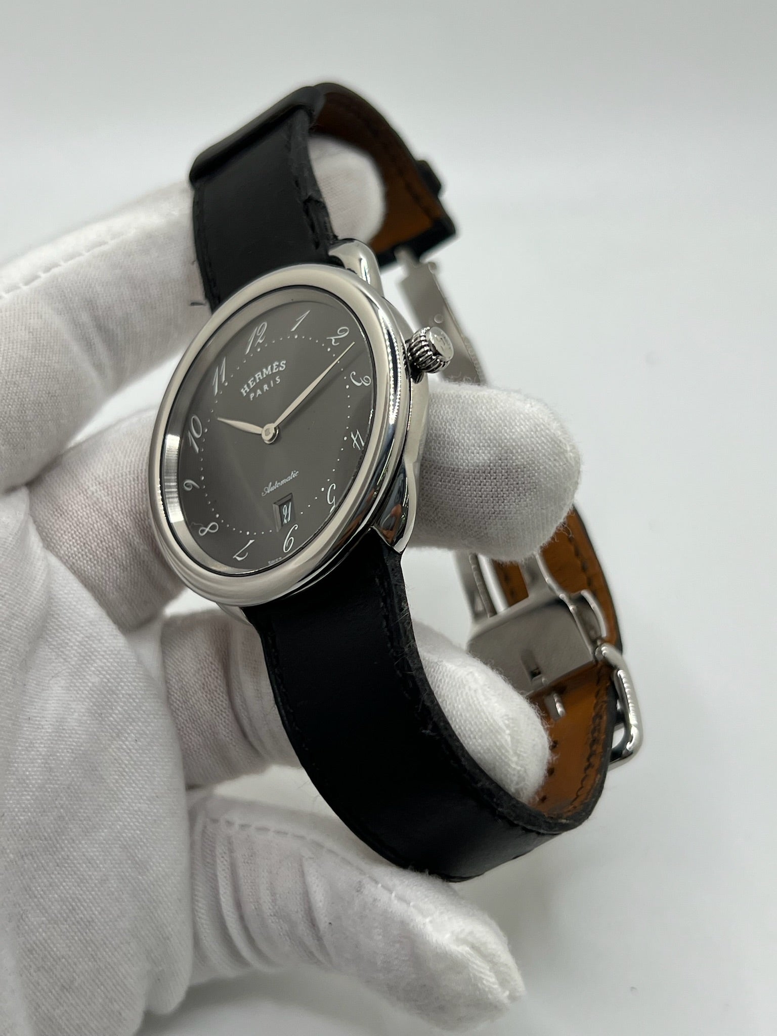 Découvrez la montre Hermès Arceau, un garde-temps d’exception alliant élégance et savoir-faire horloger. Ce modèle emblématique, doté d’un boîtier en acier de 41 mm et d’un mouvement automatique, séduit par son cadran brun raffiné et son bracelet en cuir assorti. Parfaite pour les amateurs de montres de luxe, l’Arceau incarne l’élégance à la française. 