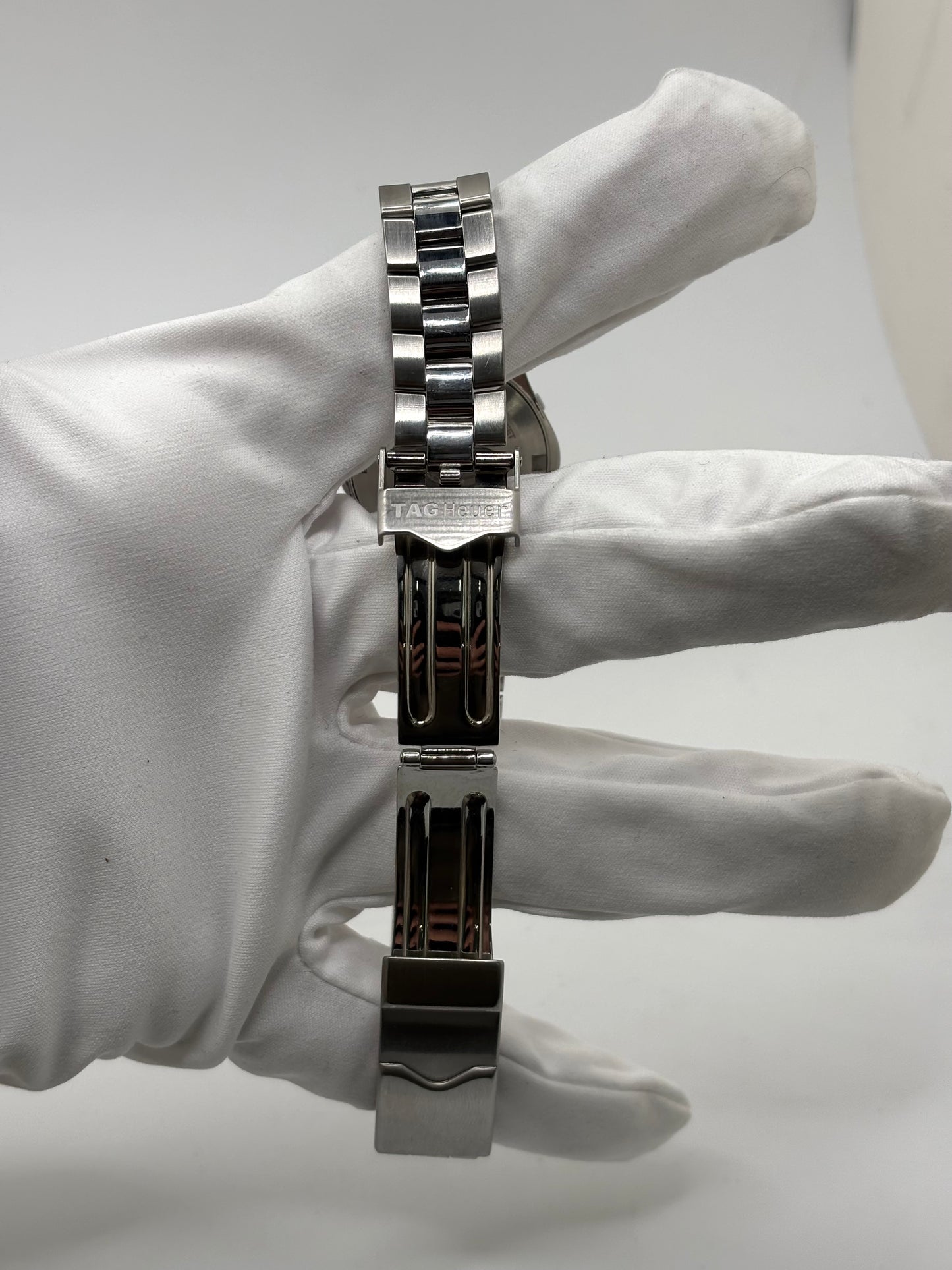 Montre femme TAG Heuer Aquaracer Lady référence WAF1412 en acier avec boîtier 27 mm et bracelet acier. Cadran argent avec chiffres arabes, mouvement quartz précis et étanchéité 30 ATM. Montre de luxe sportive et élégante en très bon état, révisée en 2026, idéale pour un usage quotidien ou une tenue habillée. Détail du boîtier acier poli, montre horlogère suisse féminine, intemporelle et raffinée.