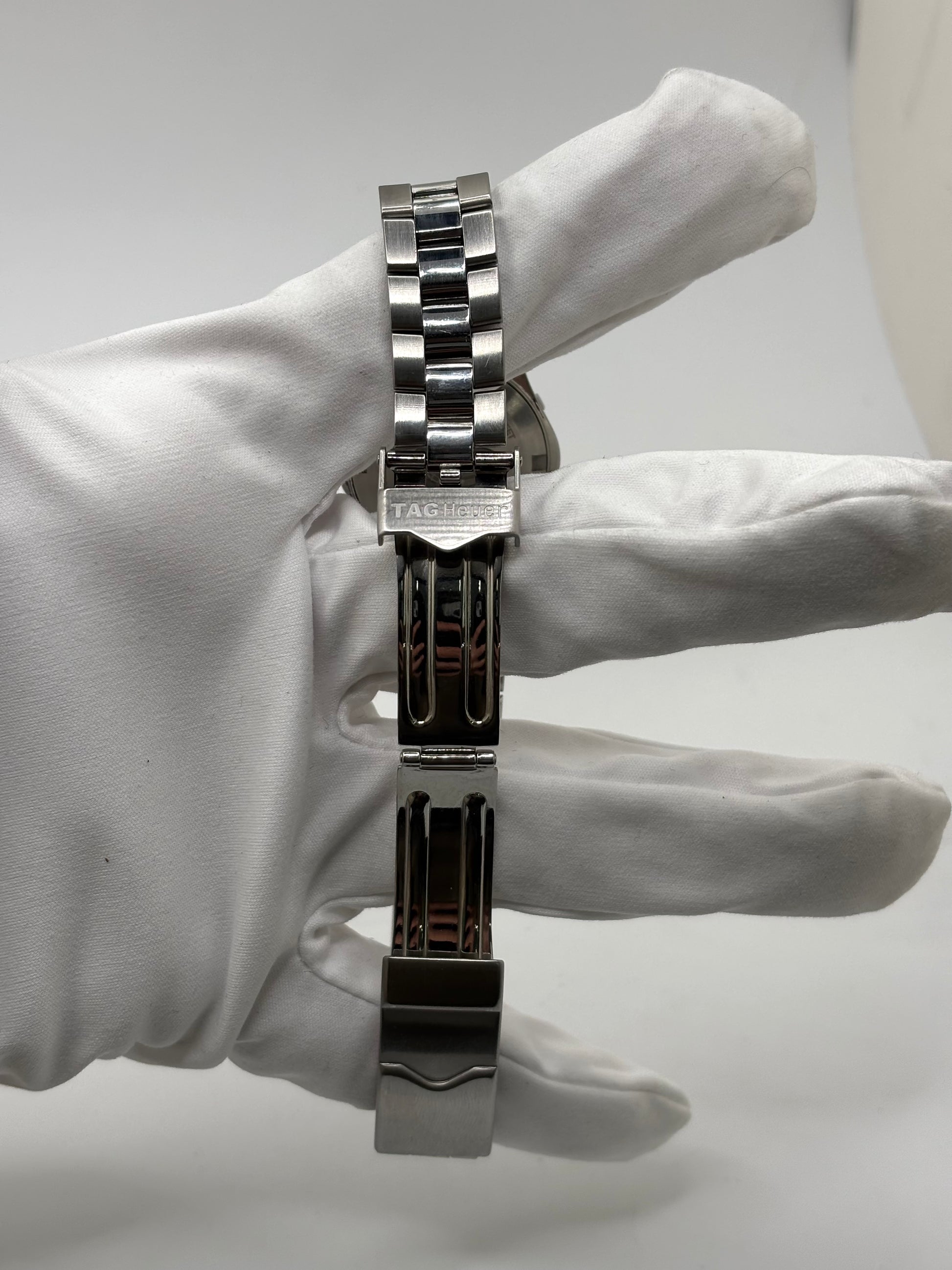 Montre femme TAG Heuer Aquaracer Lady référence WAF1412 en acier avec boîtier 27 mm et bracelet acier. Cadran argent avec chiffres arabes, mouvement quartz précis et étanchéité 30 ATM. Montre de luxe sportive et élégante en très bon état, révisée en 2026, idéale pour un usage quotidien ou une tenue habillée. Détail du boîtier acier poli, montre horlogère suisse féminine, intemporelle et raffinée.