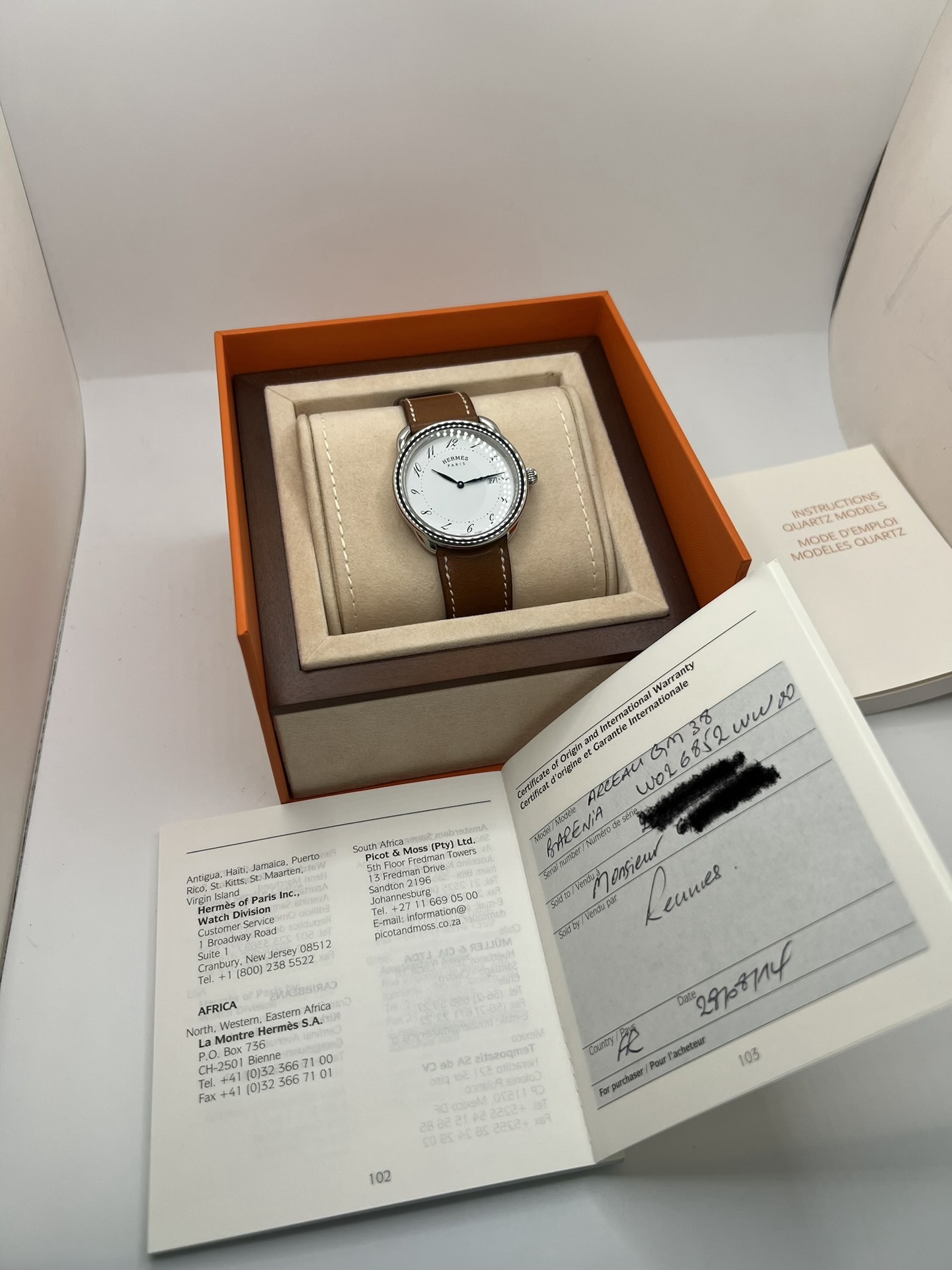 Montre Hermès Arceau Grand Modèle AR5.710 de 2014 en acier 38 mm avec mouvement quartz, cadran blanc à chiffres arabes et bracelet cuir brun d’origine. Cette montre de luxe Hermès Full Set avec boîte et papiers possède un verre saphir, une boucle ardillon acier et le design emblématique Arceau inspiré de l’univers équestre. Montre vintage Hermès élégante, révisée en 2026 et garantie 1 an.