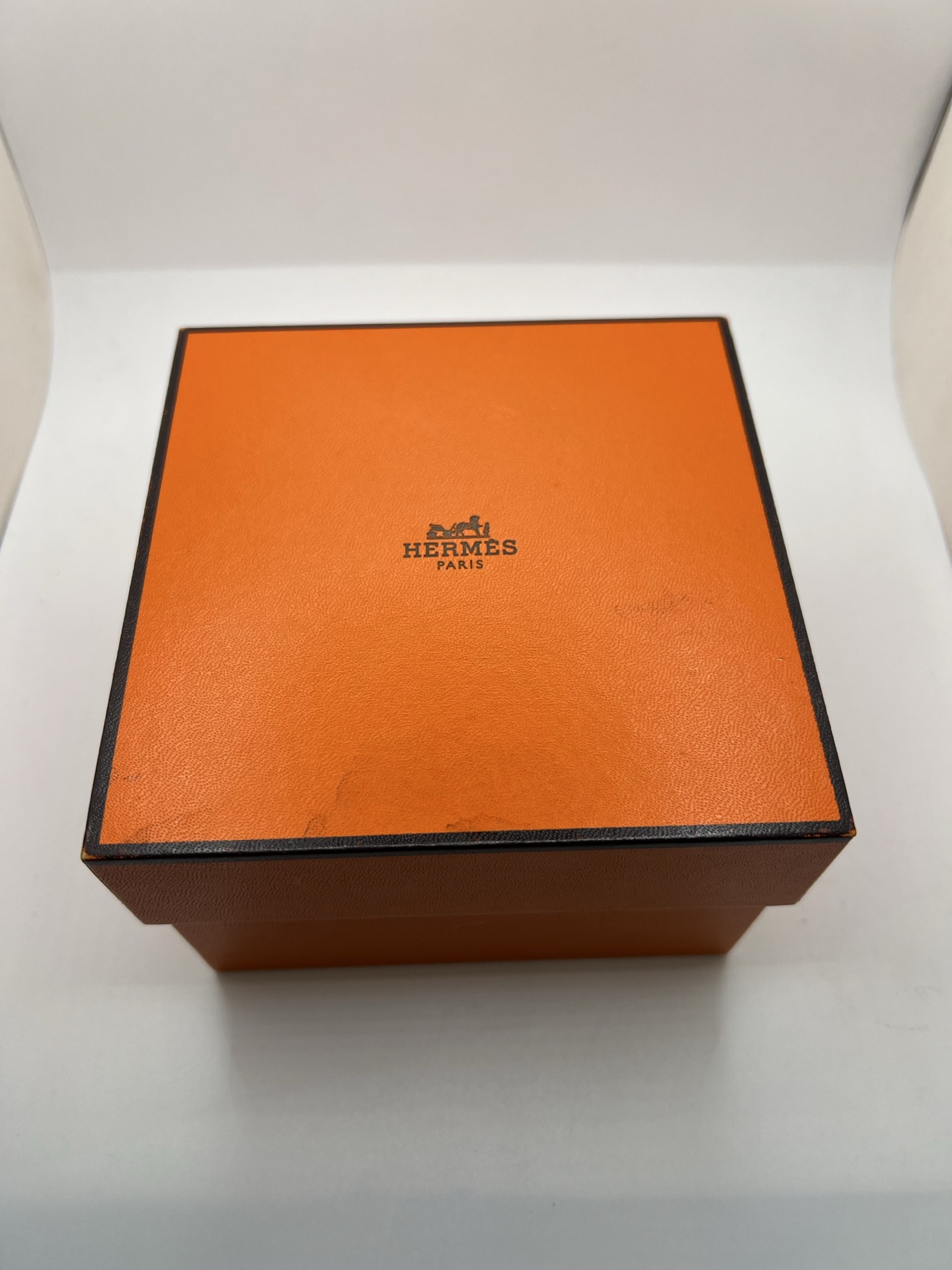 Montre Hermès Arceau Grand Modèle AR5.710 de 2014 en acier 38 mm avec mouvement quartz, cadran blanc à chiffres arabes et bracelet cuir brun d’origine. Cette montre de luxe Hermès Full Set avec boîte et papiers possède un verre saphir, une boucle ardillon acier et le design emblématique Arceau inspiré de l’univers équestre. Montre vintage Hermès élégante, révisée en 2026 et garantie 1 an.