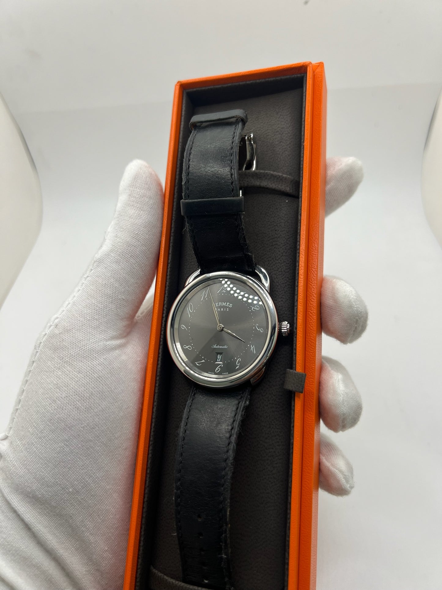 Découvrez la montre Hermès Arceau, un garde-temps d’exception alliant élégance et savoir-faire horloger. Ce modèle emblématique, doté d’un boîtier en acier de 41 mm et d’un mouvement automatique, séduit par son cadran brun raffiné et son bracelet en cuir assorti. Parfaite pour les amateurs de montres de luxe, l’Arceau incarne l’élégance à la française. 