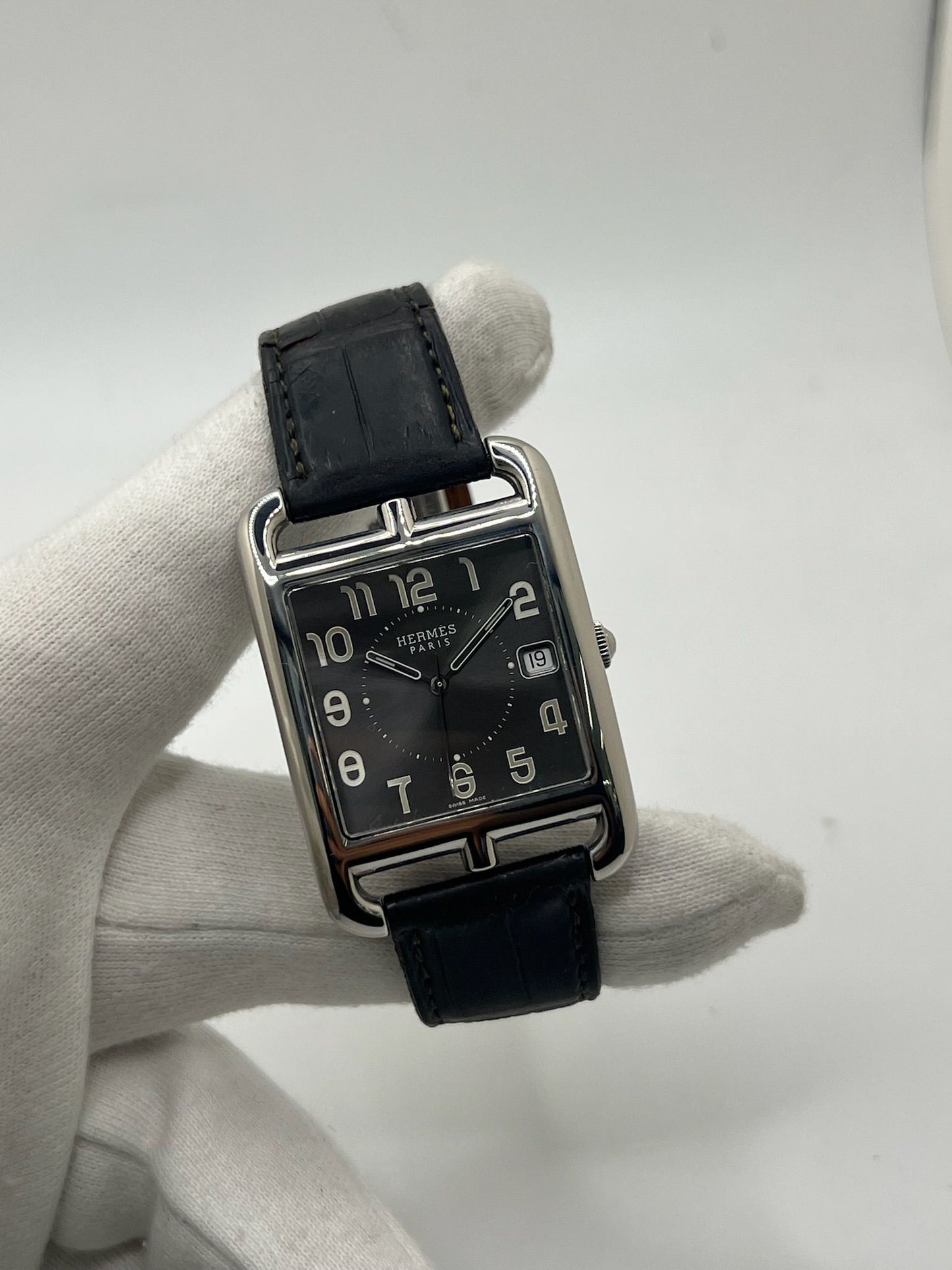 Montre Hermès Cape Cod XL pour homme ou unisexe, modèle emblématique au boîtier en acier de 33 mm. Mouvement quartz, cadran gris à chiffres arabes, bracelet cuir noir avec boucle ardillon. Élégance intemporelle signée Hermès, livrée avec coffret d’origine. Parfait état d’occasion avec légères traces d’usure. Disponible à Paris, prix négociable. Idéal collectionneur ou amateur de montres de luxe.