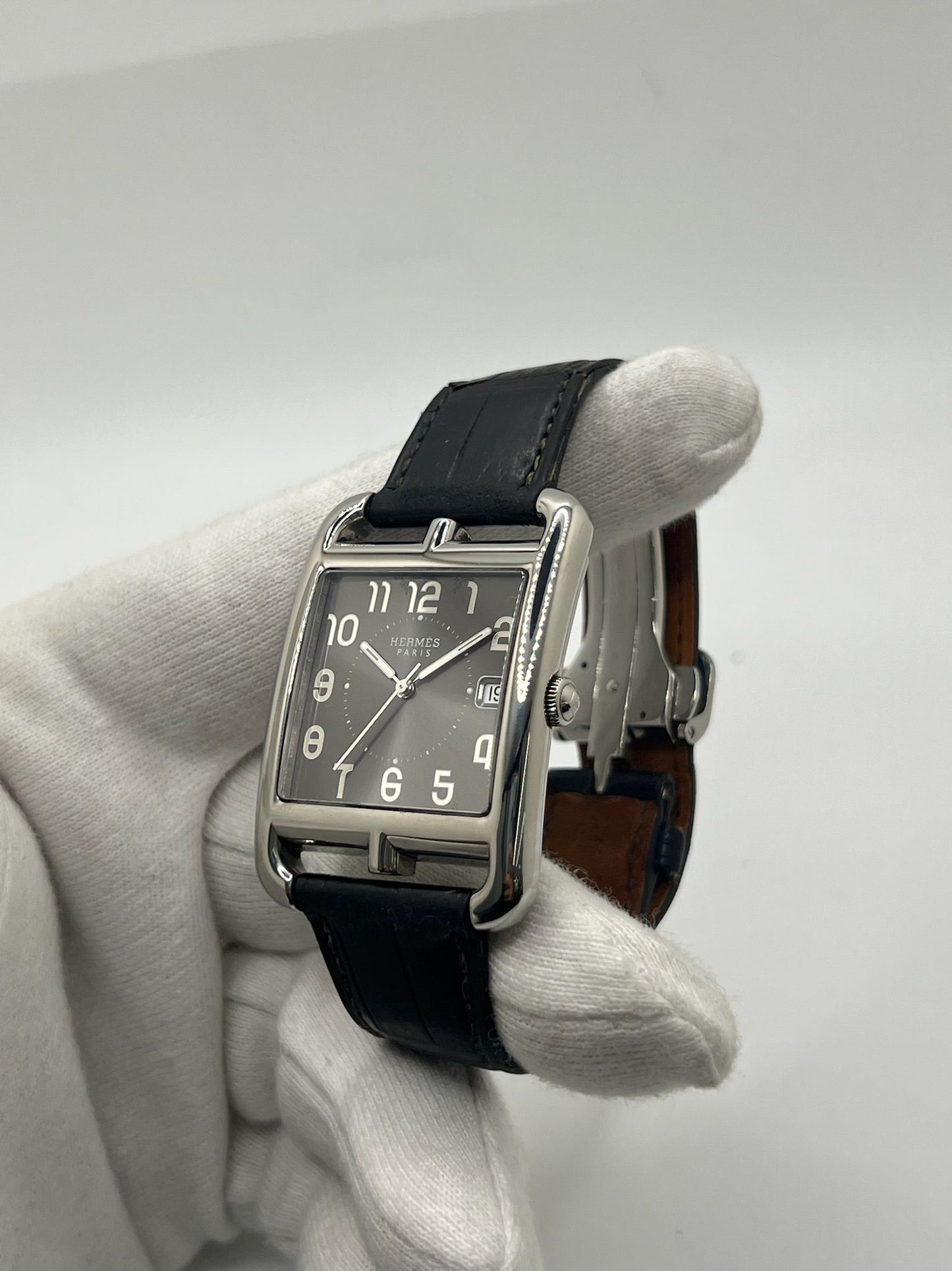 Montre Hermès Cape Cod XL pour homme ou unisexe, modèle emblématique au boîtier en acier de 33 mm. Mouvement quartz, cadran gris à chiffres arabes, bracelet cuir noir avec boucle ardillon. Élégance intemporelle signée Hermès, livrée avec coffret d’origine. Parfait état d’occasion avec légères traces d’usure. Disponible à Paris, prix négociable. Idéal collectionneur ou amateur de montres de luxe.