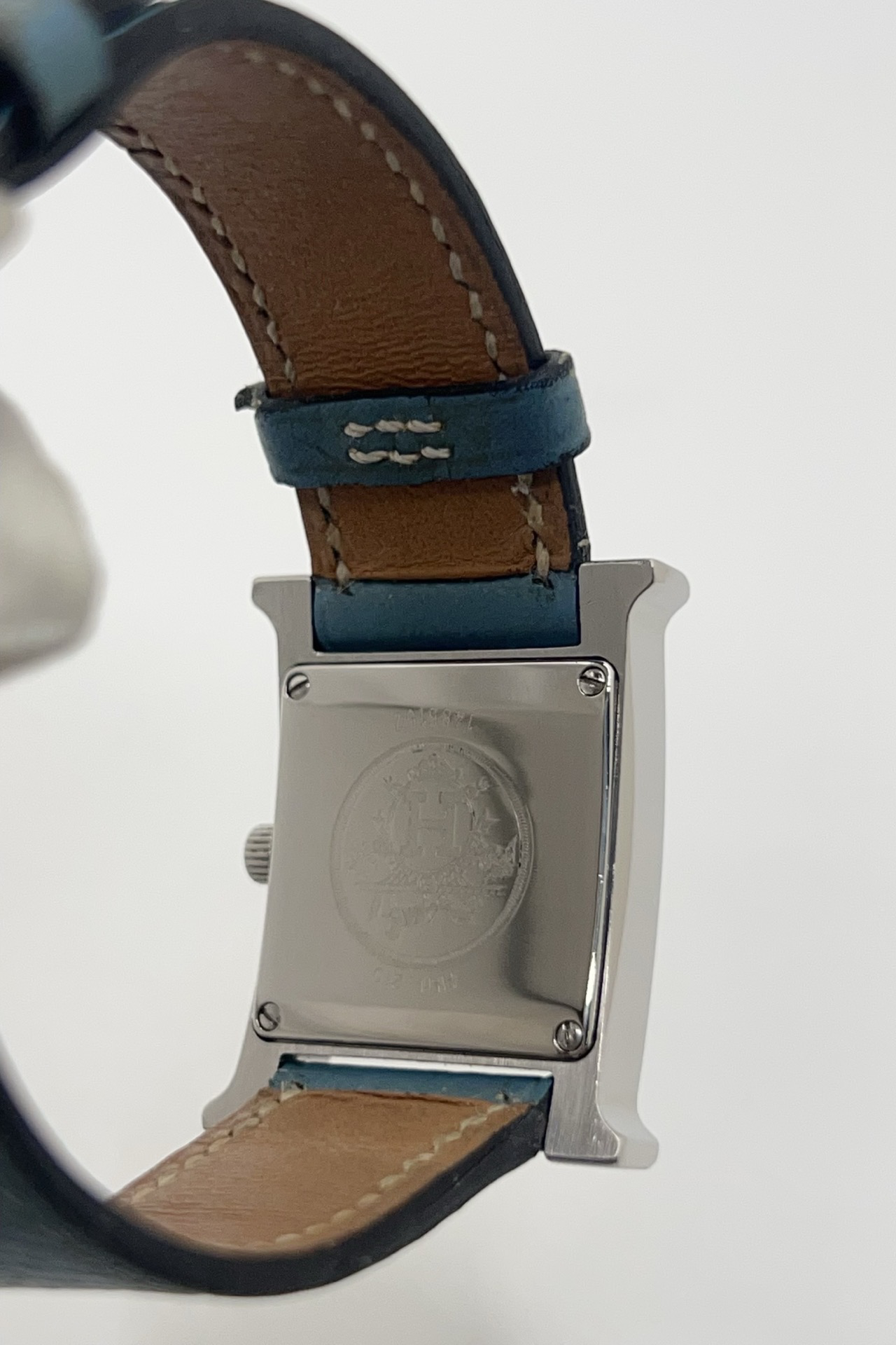 Montre Hermès Heure H HH1.210 en acier avec cadran bleu à chiffres arabes et bracelet cuir Hermès bleu d’origine. Cette montre Hermès femme quartz au design iconique en forme de H incarne l’élégance parisienne et le luxe discret. Modèle Hermès Heure H acier de 21 x 30 mm avec verre saphir, boucle ardillon acier et mouvement quartz fiable. Montre de luxe féminine chic et intemporelle, révisée et livrée avec certificat d’authenticité.