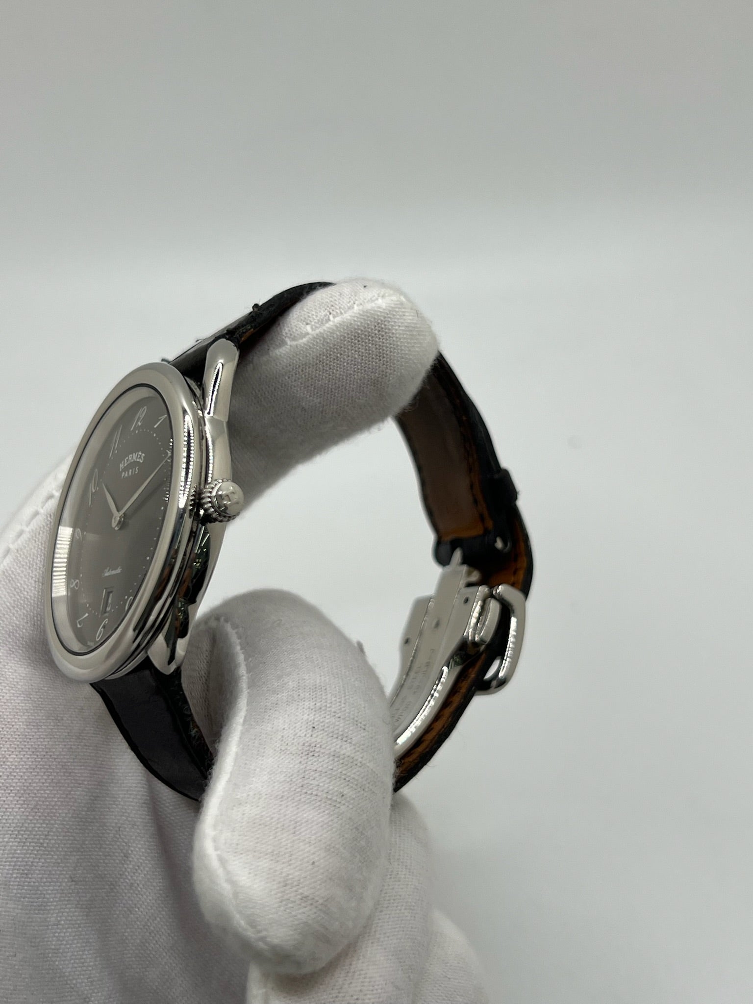 Découvrez la montre Hermès Arceau, un garde-temps d’exception alliant élégance et savoir-faire horloger. Ce modèle emblématique, doté d’un boîtier en acier de 41 mm et d’un mouvement automatique, séduit par son cadran brun raffiné et son bracelet en cuir assorti. Parfaite pour les amateurs de montres de luxe, l’Arceau incarne l’élégance à la française. 
