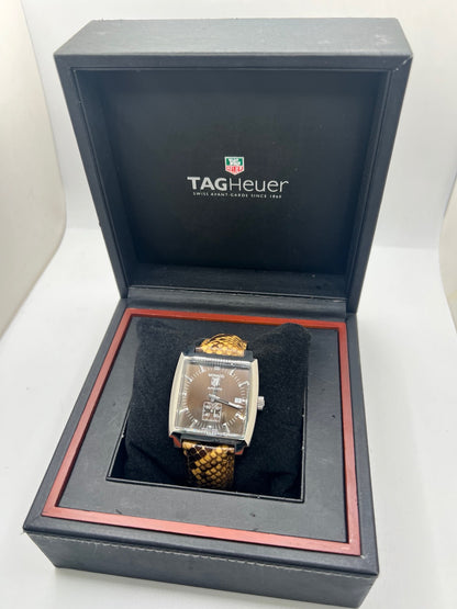Montre TAG Heuer Monaco Calibre 6 WW2115 pour homme, équipée d’un mouvement automatique offrant une réserve de marche de 42 heures et du calibre 6 doté de 27 pierres. Son boîtier en acier de 37 mm accueille un cadran brun au style élégant et distinctif. Cette TAG Heuer Monaco est montée sur un bracelet en cuir de serpent avec boucle déployante en acier. Dotée d’un affichage de la date, elle allie design emblématique et savoir-faire horloger. Vendue avec son coffret d’origine, en très bon état.