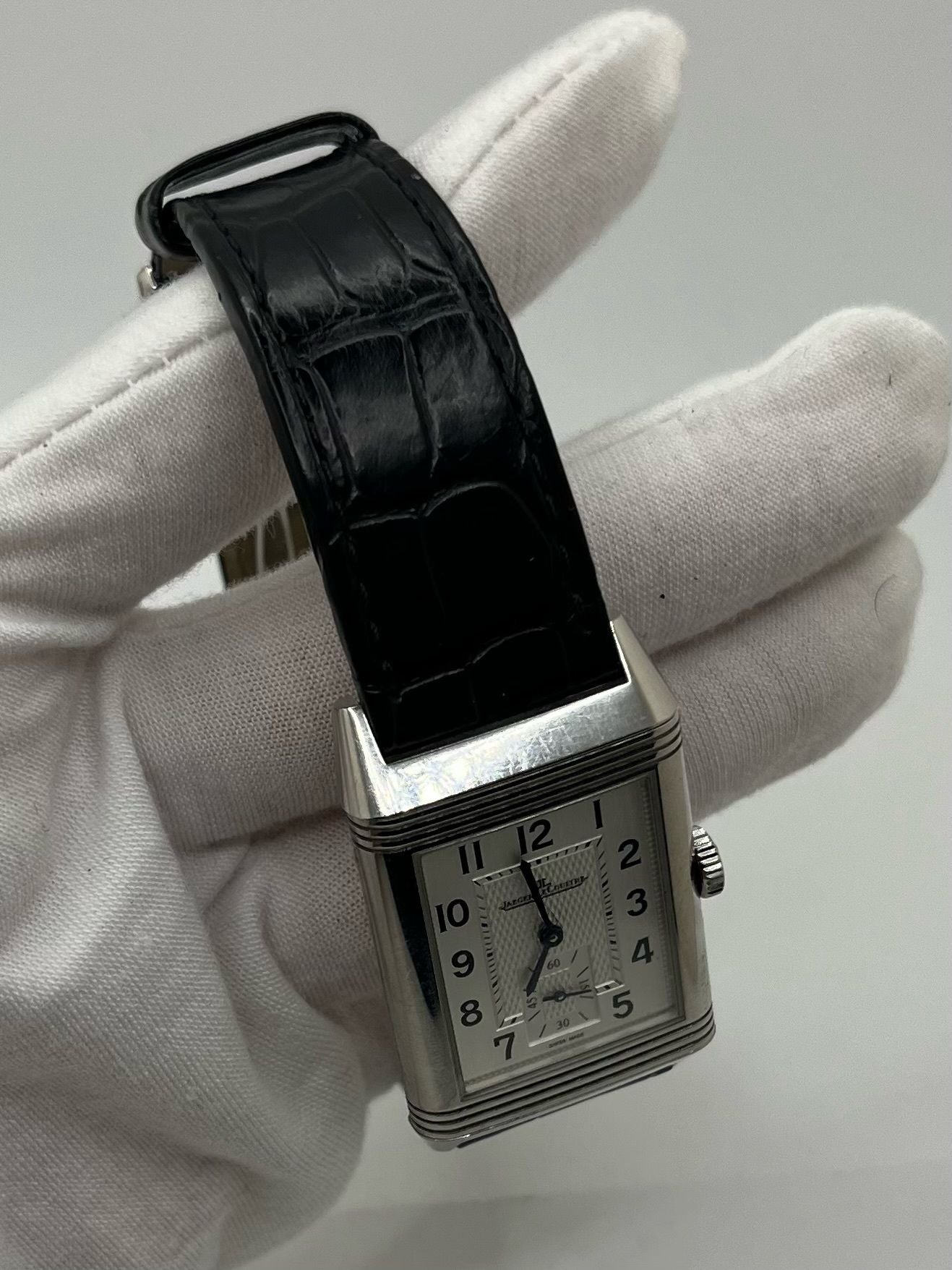 Montre Jaeger-LeCoultre Reverso Classic Small/Large réf. 214.8.62, modèle emblématique de 2017, livrée en full set avec boîte et papiers d’origine. Équipée d’une élégante boucle déployante, cette montre mécanique incarne le savoir-faire horloger suisse. Boîtier rectangulaire en acier, mouvement à remontage manuel. Une pièce raffinée pour collectionneur ou amateur de montres de prestige.