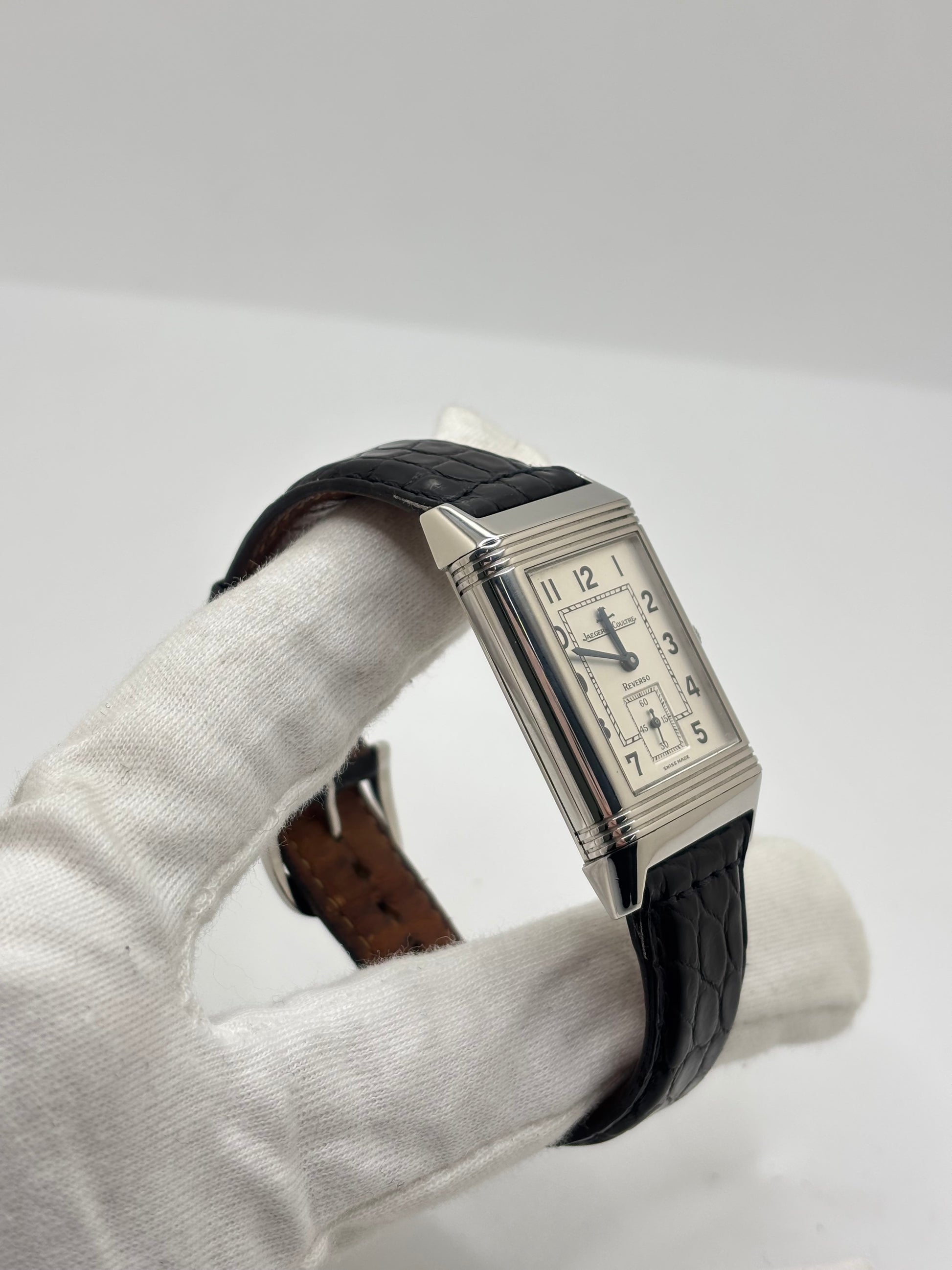 Montre Jaeger-LeCoultre Reverso Grande Taille 270.8.62 en acier, mouvement mécanique à remontage manuel calibre 822. Boîtier rectangulaire 26 x 42 mm, cadran argent à chiffres arabes, petite seconde, verre saphir. Bracelet cuir noir boucle ardillon acier. Modèle 1997 en très bon état, révisé le 4 juin 2026, livré avec coffret et papiers d’origine. Montre de luxe suisse emblématique, design Art déco, style vintage élégant. pièce horlogère iconique.
