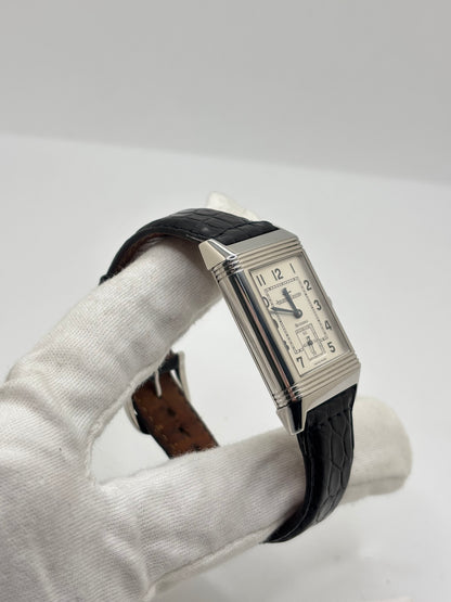 Montre Jaeger-LeCoultre Reverso Grande Taille 270.8.62 en acier, mouvement mécanique à remontage manuel calibre 822. Boîtier rectangulaire 26 x 42 mm, cadran argent à chiffres arabes, petite seconde, verre saphir. Bracelet cuir noir boucle ardillon acier. Modèle 1997 en très bon état, révisé le 4 juin 2026, livré avec coffret et papiers d’origine. Montre de luxe suisse emblématique, design Art déco, style vintage élégant. pièce horlogère iconique.
