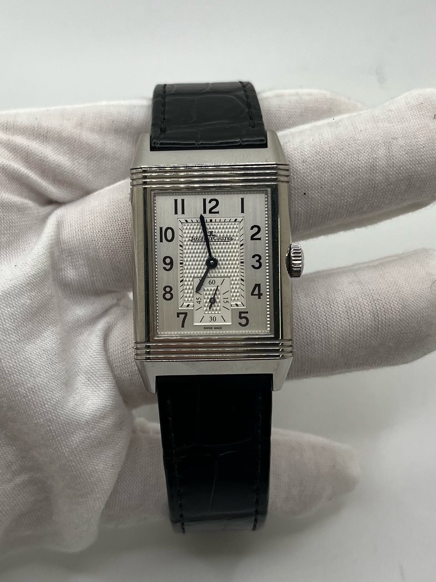 Montre Jaeger-LeCoultre Reverso Classic Small/Large réf. 214.8.62, modèle emblématique de 2017, livrée en full set avec boîte et papiers d’origine. Équipée d’une élégante boucle déployante, cette montre mécanique incarne le savoir-faire horloger suisse. Boîtier rectangulaire en acier, mouvement à remontage manuel. Une pièce raffinée pour collectionneur ou amateur de montres de prestige.