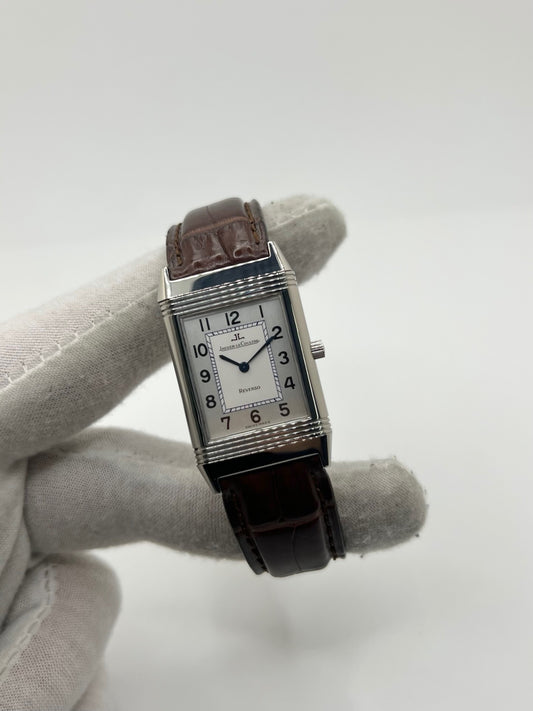 Montre Jaeger-LeCoultre Reverso Classique pour homme ou unisexe, équipée d’un mouvement quartz et d’un boîtier en acier de 23 x 38 mm. Ce modèle d’occasion en très bon état dispose d’un cadran argent à chiffres arabes, d’un verre saphir et d’une étanchéité de 3 ATM. Son bracelet en cuir brun avec boucle ardillon complète son style élégant et intemporel. Une montre Jaeger-LeCoultre Reverso Classique raffinée, idéale pour les amateurs de montres de luxe classiques.