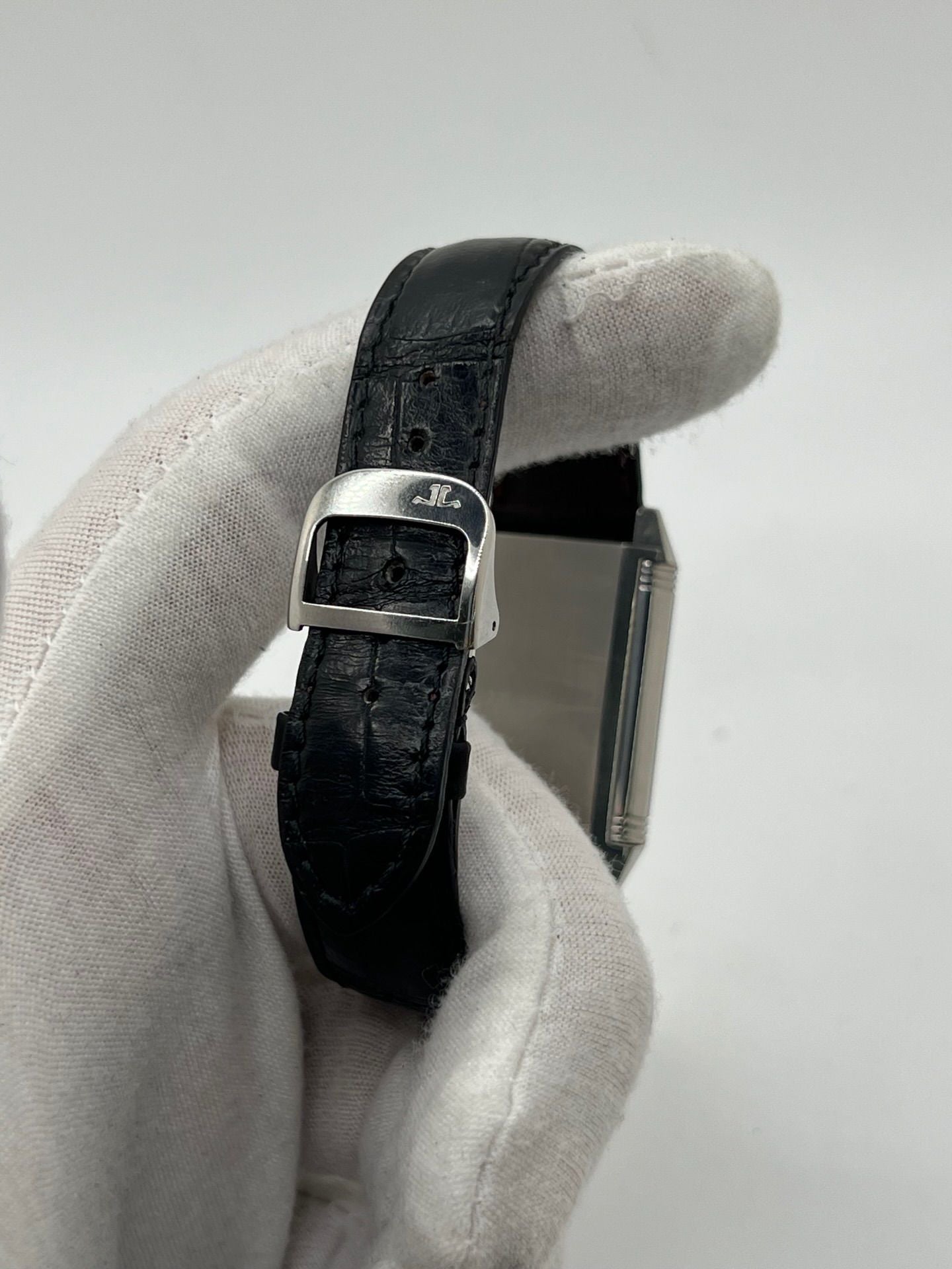 Découvrez la Jaeger-LeCoultre Reverso Grande Taille pour homme/unisexe, modèle 2008 en acier avec bracelet cuir brun. Montre de luxe à remontage manuel, calibre 822, 45 h de réserve de marche, petite seconde et cadran argent. État très bon, avec coffret et papiers d’origine.