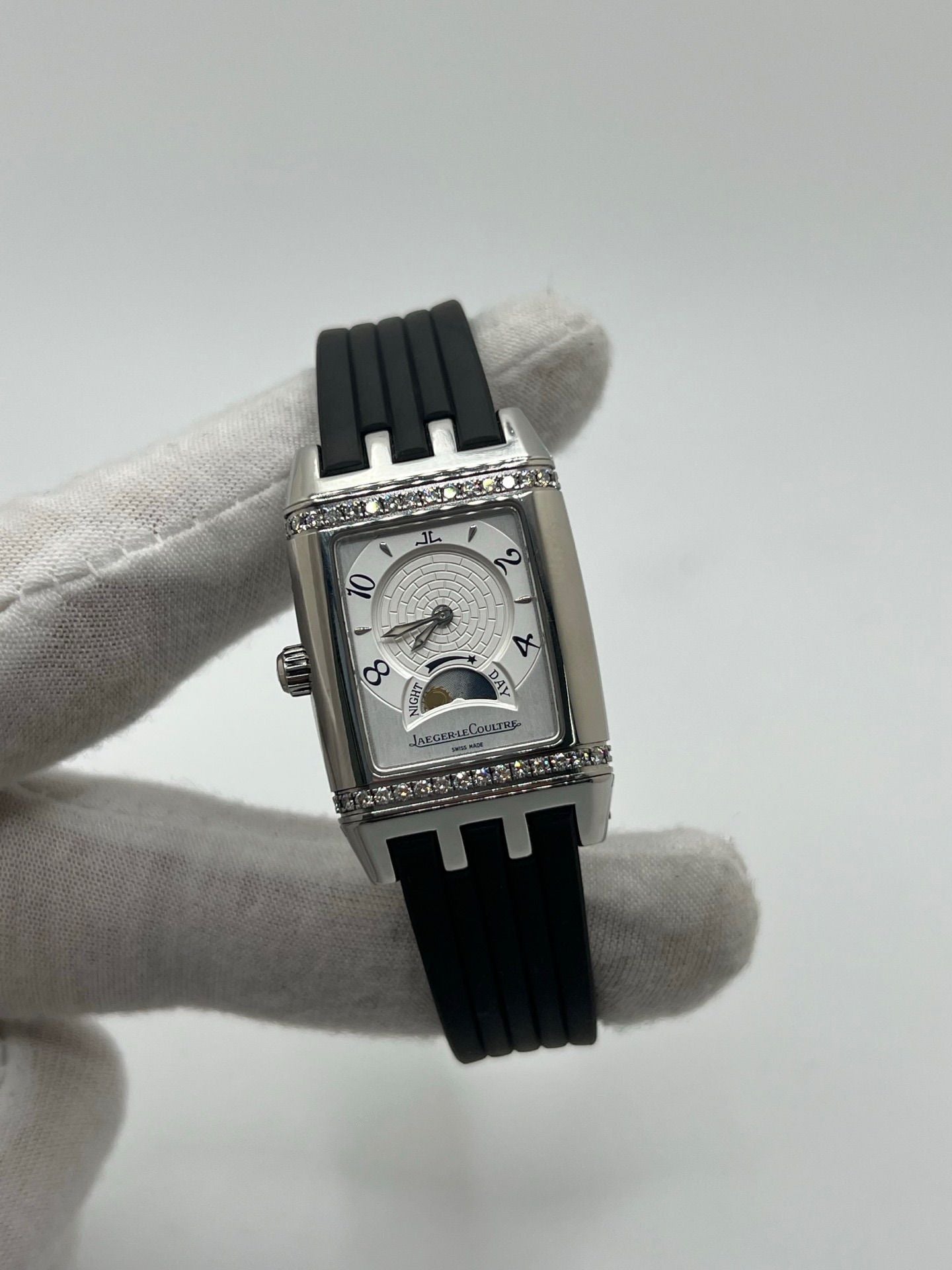 Montre Reverso Duetto référence 296.8.74 en acier, format rectangulaire, équipée d’un mouvement à remontage manuel. Modèle pour femme avec cadran blanc à chiffres arabes et verre saphir. Brace­let en caoutchouc noir avec boucle double plis. Pièce d’occasion en très bon état, présentant de légères traces d’usure discrètes.
