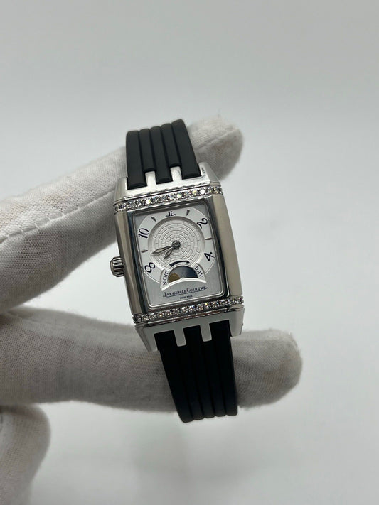 Montre Reverso Duetto référence 296.8.74 en acier, format rectangulaire, équipée d’un mouvement à remontage manuel. Modèle pour femme avec cadran blanc à chiffres arabes et verre saphir. Brace­let en caoutchouc noir avec boucle double plis. Pièce d’occasion en très bon état, présentant de légères traces d’usure discrètes.