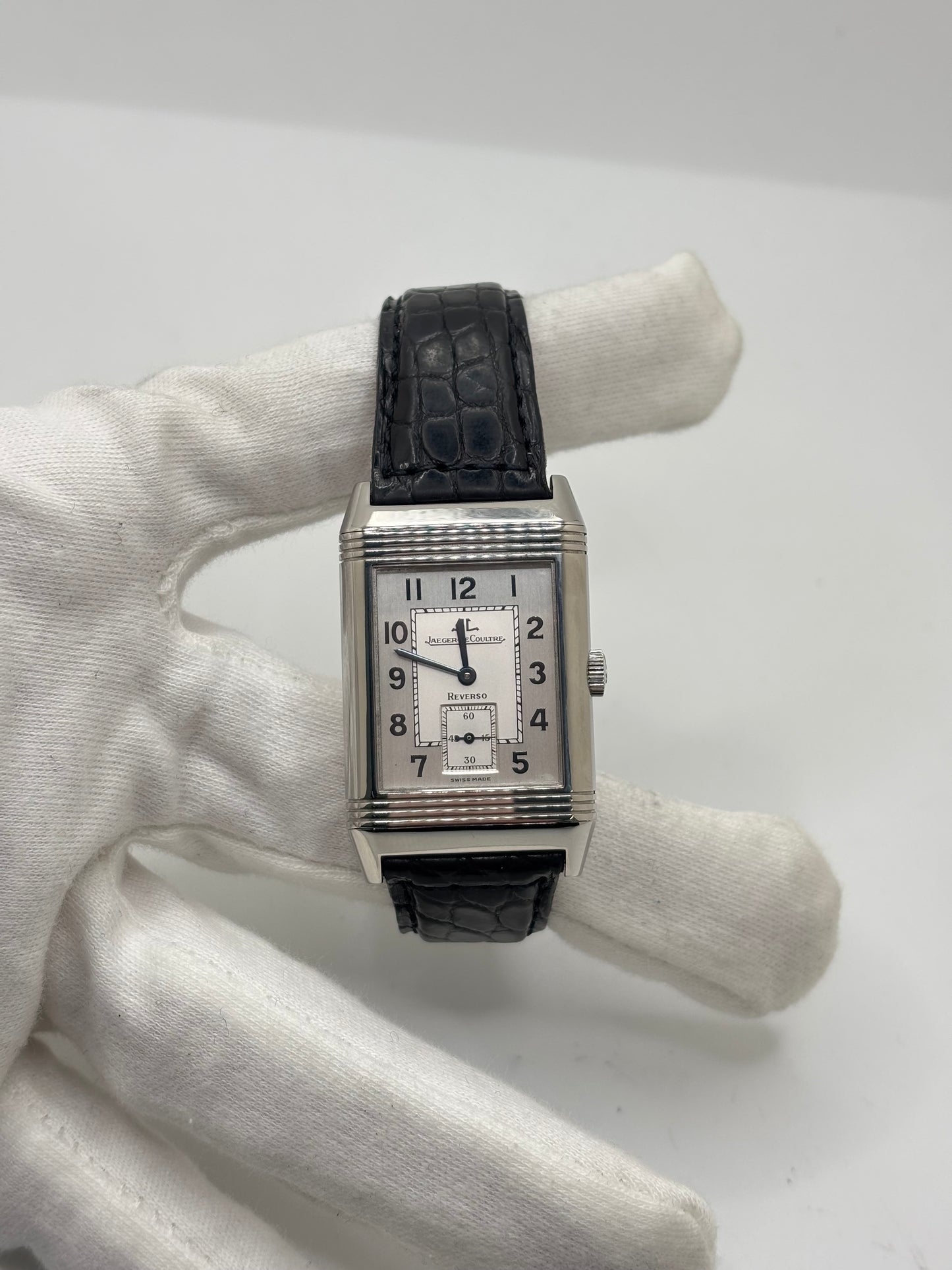 Montre Jaeger-LeCoultre Reverso Grande Taille 270.8.62 en acier, mouvement mécanique à remontage manuel calibre 822. Boîtier rectangulaire 26 x 42 mm, cadran argent à chiffres arabes, petite seconde, verre saphir. Bracelet cuir noir boucle ardillon acier. Modèle 1997 en très bon état, révisé le 4 juin 2026, livré avec coffret et papiers d’origine. Montre de luxe suisse emblématique, design Art déco, style vintage élégant. pièce horlogère iconique.
