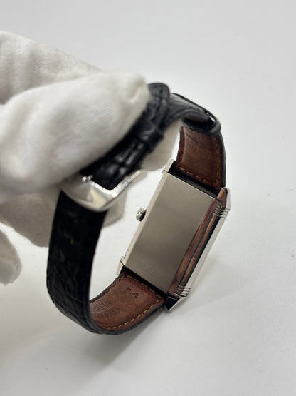 Montre Jaeger-LeCoultre Reverso Grande Taille 270.8.62 en acier, mouvement mécanique à remontage manuel calibre 822. Boîtier rectangulaire 26 x 42 mm, cadran argent à chiffres arabes, petite seconde, verre saphir. Bracelet cuir noir boucle ardillon acier. Modèle 1997 en très bon état, révisé le 4 juin 2026, livré avec coffret et papiers d’origine. Montre de luxe suisse emblématique, design Art déco, style vintage élégant. pièce horlogère iconique.
