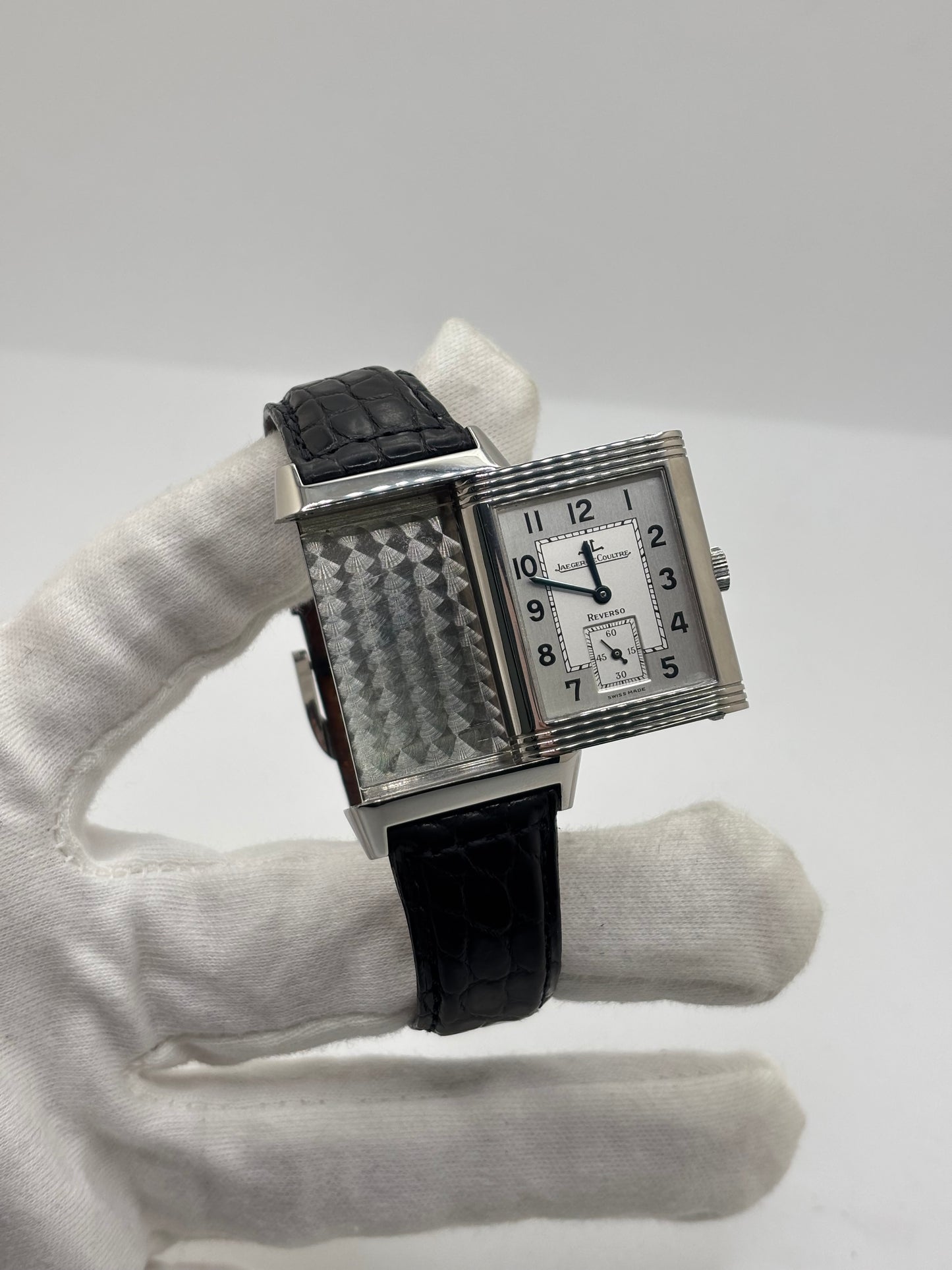 Montre Jaeger-LeCoultre Reverso Grande Taille 270.8.62 en acier, mouvement mécanique à remontage manuel calibre 822. Boîtier rectangulaire 26 x 42 mm, cadran argent à chiffres arabes, petite seconde, verre saphir. Bracelet cuir noir boucle ardillon acier. Modèle 1997 en très bon état, révisé le 4 juin 2026, livré avec coffret et papiers d’origine. Montre de luxe suisse emblématique, design Art déco, style vintage élégant. pièce horlogère iconique.
