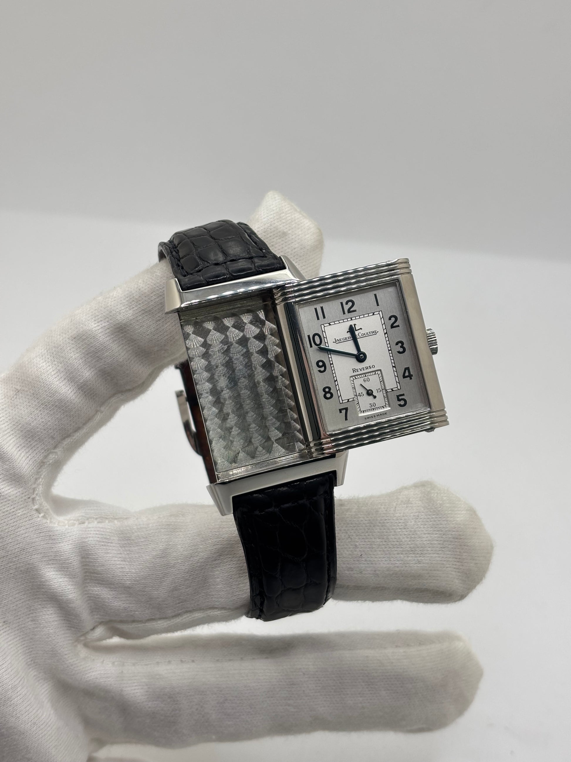 Montre Jaeger-LeCoultre Reverso Grande Taille 270.8.62 en acier, mouvement mécanique à remontage manuel calibre 822. Boîtier rectangulaire 26 x 42 mm, cadran argent à chiffres arabes, petite seconde, verre saphir. Bracelet cuir noir boucle ardillon acier. Modèle 1997 en très bon état, révisé le 4 juin 2026, livré avec coffret et papiers d’origine. Montre de luxe suisse emblématique, design Art déco, style vintage élégant. pièce horlogère iconique.
