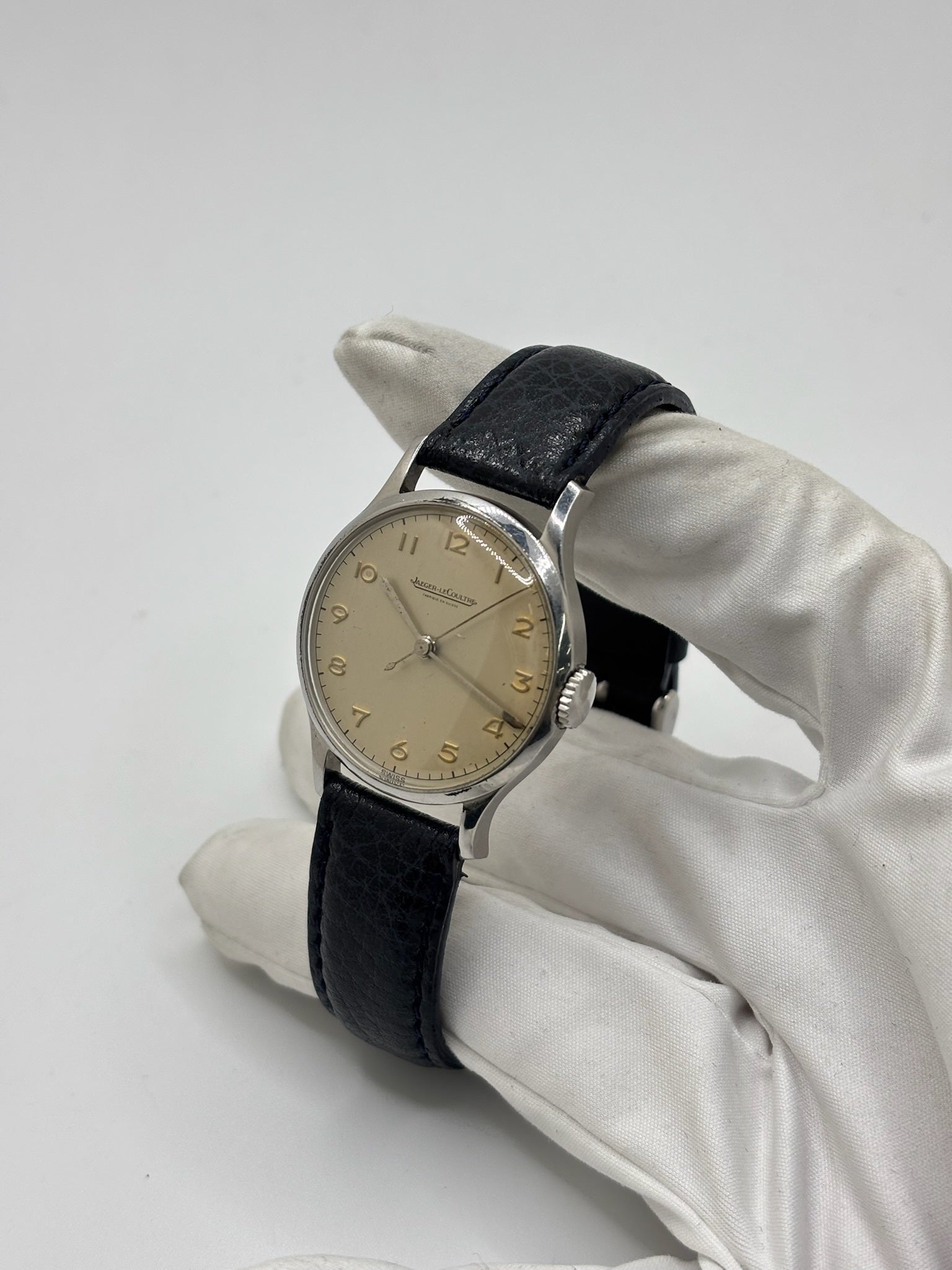 Montre Jaeger-LeCoultre vintage en acier datant des années 1950, équipée du calibre P478 à remontage manuel. Son cadran argent à chiffres arabes est protégé par un verre plexiglas et associé à un bracelet en cuir noir. Avec son boîtier de 31,5 mm et son design sobre et élégant, cette montre mécanique de collection illustre le savoir-faire horloger suisse de l'époque. Pièce ancienne recherchée par les amateurs de montres vintage et de garde-temps de caractère.