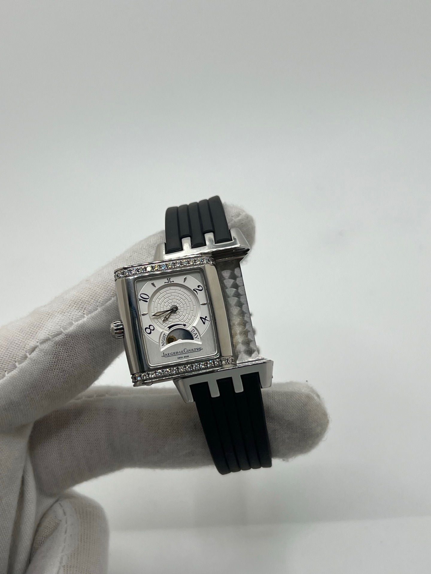 Montre Reverso Duetto référence 296.8.74 en acier, format rectangulaire, équipée d’un mouvement à remontage manuel. Modèle pour femme avec cadran blanc à chiffres arabes et verre saphir. Brace­let en caoutchouc noir avec boucle double plis. Pièce d’occasion en très bon état, présentant de légères traces d’usure discrètes.