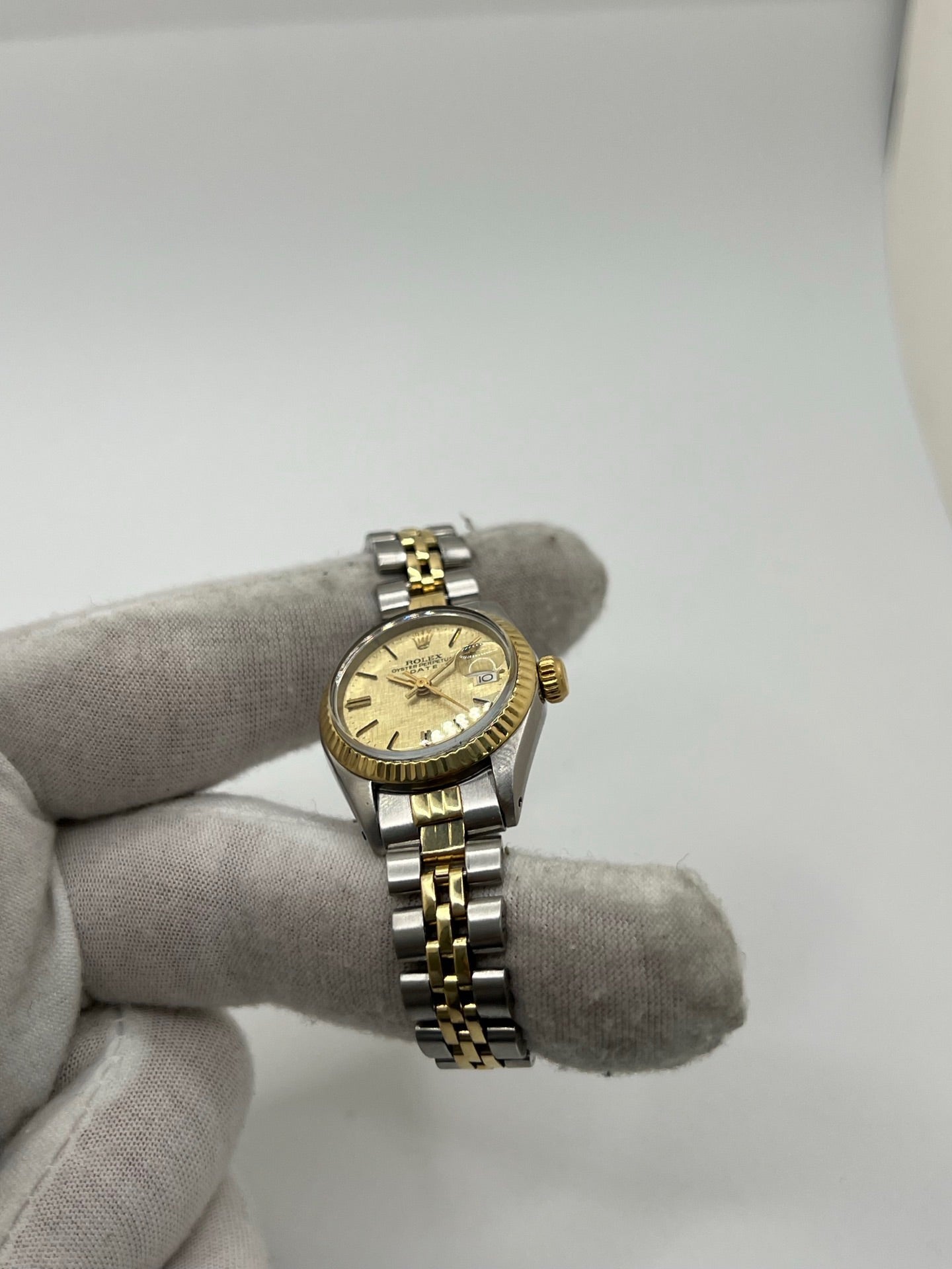 Montre Lady-Datejust référence 69173 en acier et or jaune avec cadran champagne et lunette cannelée en or jaune. Modèle féminin emblématique doté d’un mouvement automatique calibre 2135 et d’un boîtier de 26 mm avec verre saphir. Bracelet bicolore acier et or avec boucle pliante. Montre élégante et intemporelle, appréciée pour son design raffiné et sa fonction date, idéale pour les amateurs de montres classiques et d’horlogerie suisse.