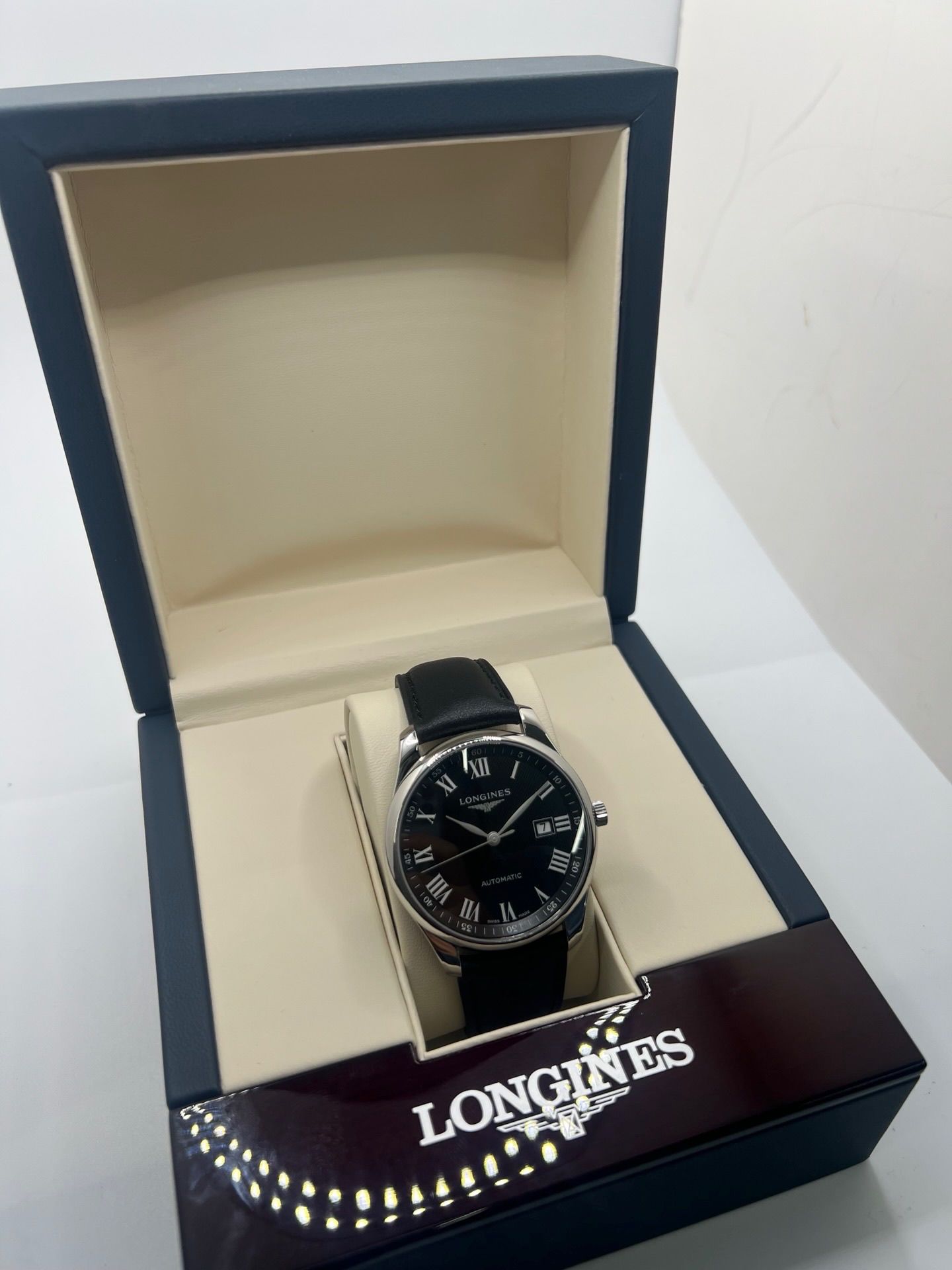 Montre automatique Longines Master Collection L2.893.4.51.6 en acier 42 mm, équipée d’un cadran noir épuré, d’un verre saphir et d’un bracelet en cuir noir. Modèle élégant avec fonction date, en très bon état d’occasion, présentant de légères micro-rayures, livré avec coffret d’origine.