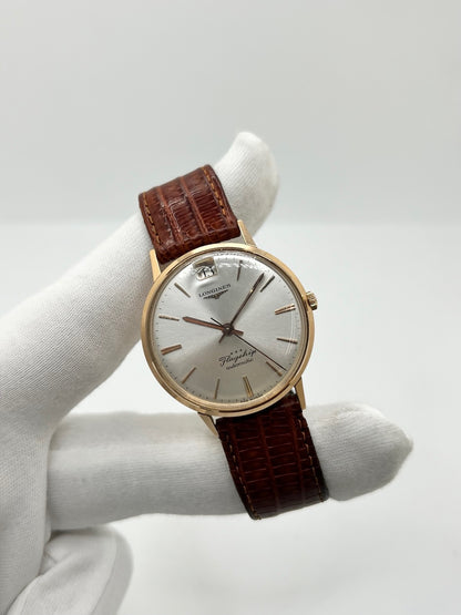 Montre Longines Flagship 2407 vintage en très bon état, datant approximativement de 1962, avec mouvement automatique calibre 341. Son boîtier de 35 mm en or rose est associé à un cadran argent à index bâtons et un verre Plexiglas. Cette Longines Flagship possède un bracelet en cuir de lézard brun avec boucle ardillon en acier. Elle dispose également d’une fonction date et d’un design élégant et intemporel.