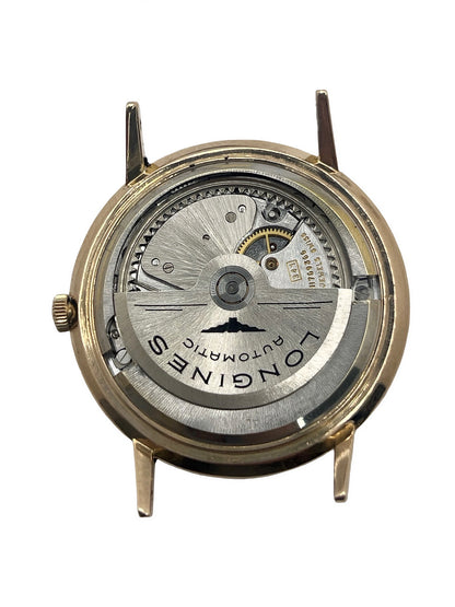 Montre Longines Flagship 2407 vintage en très bon état, datant approximativement de 1962, avec mouvement automatique calibre 341. Son boîtier de 35 mm en or rose est associé à un cadran argent à index bâtons et un verre Plexiglas. Cette Longines Flagship possède un bracelet en cuir de lézard brun avec boucle ardillon en acier. Elle dispose également d’une fonction date et d’un design élégant et intemporel.