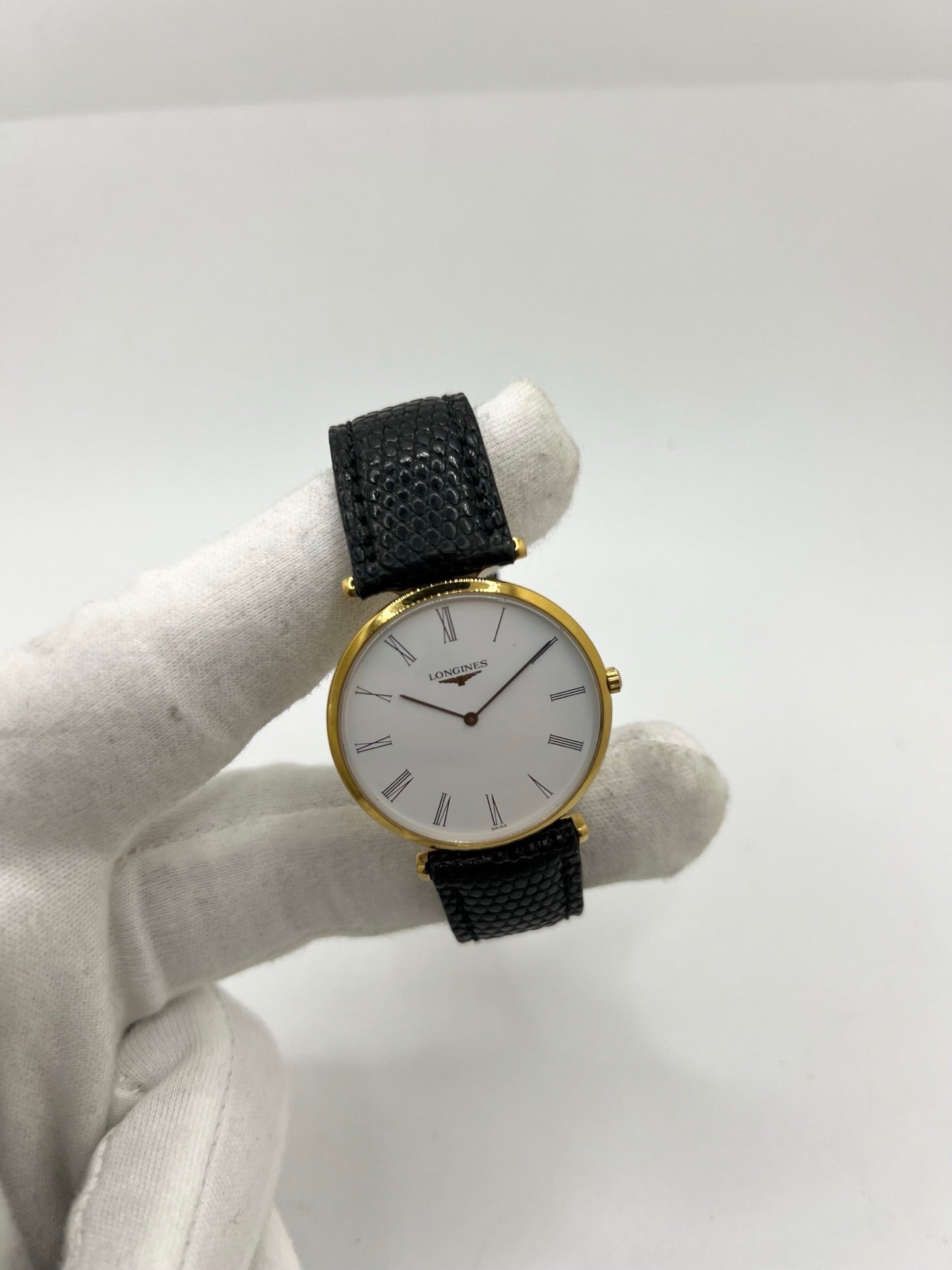 Montre Longines La Grande Classique référence L4.709.2 en plaqué or avec boîtier de 33 mm, cadran blanc à chiffres romains et verre saphir. Ce modèle à mouvement quartz est équipé d’un bracelet en cuir noir avec boucle ardillon en acier. Son design élégant et intemporel en fait une montre de ville raffinée, adaptée aussi bien aux hommes qu’aux amateurs de montres classiques. Pièce d’occasion en très bon état, révisée et prête à être portée.
