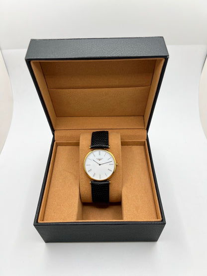 Montre Longines La Grande Classique référence L4.709.2 en plaqué or avec boîtier de 33 mm, cadran blanc à chiffres romains et verre saphir. Ce modèle à mouvement quartz est équipé d’un bracelet en cuir noir avec boucle ardillon en acier. Son design élégant et intemporel en fait une montre de ville raffinée, adaptée aussi bien aux hommes qu’aux amateurs de montres classiques. Pièce d’occasion en très bon état, révisée et prête à être portée.
