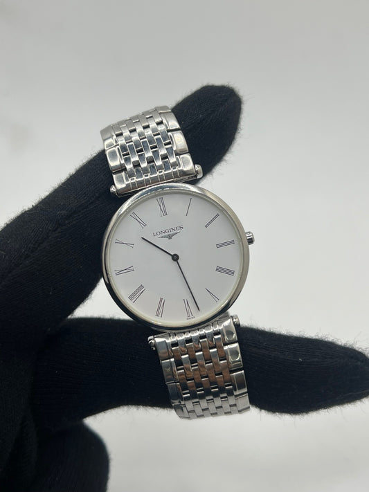 Montre Longines La Grande Classique L4.709.4 en acier, équipée d’un mouvement quartz précis et d’un cadran blanc à chiffres romains. Son boîtier fin de 33 mm et son bracelet argenté en acier lui confèrent une élégance intemporelle. Un garde-temps raffiné pour homme ou unisexe, idéal pour un style classique et sophistiqué.