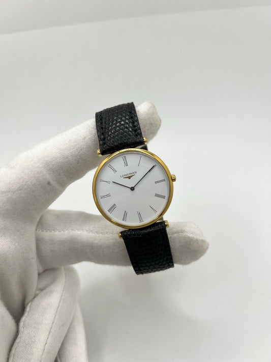 Montre Longines La Grande Classique référence L4.709.2 en plaqué or avec boîtier de 33 mm, cadran blanc à chiffres romains et verre saphir. Ce modèle à mouvement quartz est équipé d’un bracelet en cuir noir avec boucle ardillon en acier. Son design élégant et intemporel en fait une montre de ville raffinée, adaptée aussi bien aux hommes qu’aux amateurs de montres classiques. Pièce d’occasion en très bon état, révisée et prête à être portée.
