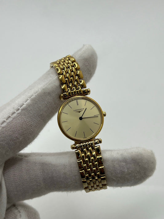Montre femme Longines La Grande Classique plaquée or avec boîtier acier et bracelet doré. Cadran or avec index bâtons, verre saphir, mouvement quartz précis. Élégante et raffinée, idéale pour un usage quotidien ou des occasions spéciales. D’occasion en très bon état, légère usure discrète, sans coffret ni papiers d’origine.