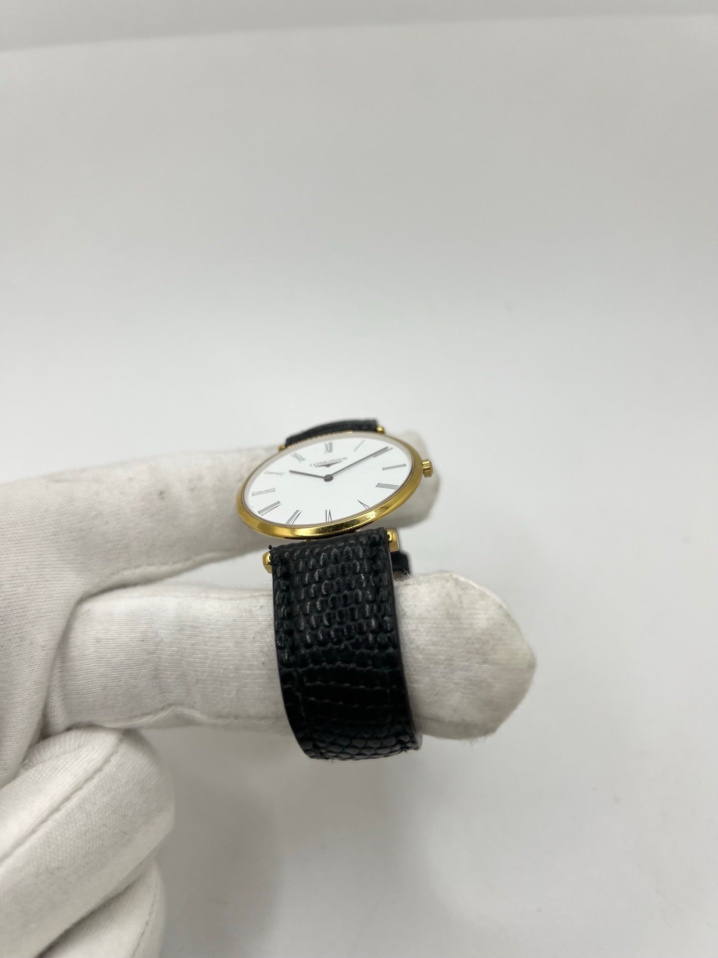 Montre Longines La Grande Classique référence L4.709.2 en plaqué or avec boîtier de 33 mm, cadran blanc à chiffres romains et verre saphir. Ce modèle à mouvement quartz est équipé d’un bracelet en cuir noir avec boucle ardillon en acier. Son design élégant et intemporel en fait une montre de ville raffinée, adaptée aussi bien aux hommes qu’aux amateurs de montres classiques. Pièce d’occasion en très bon état, révisée et prête à être portée.
