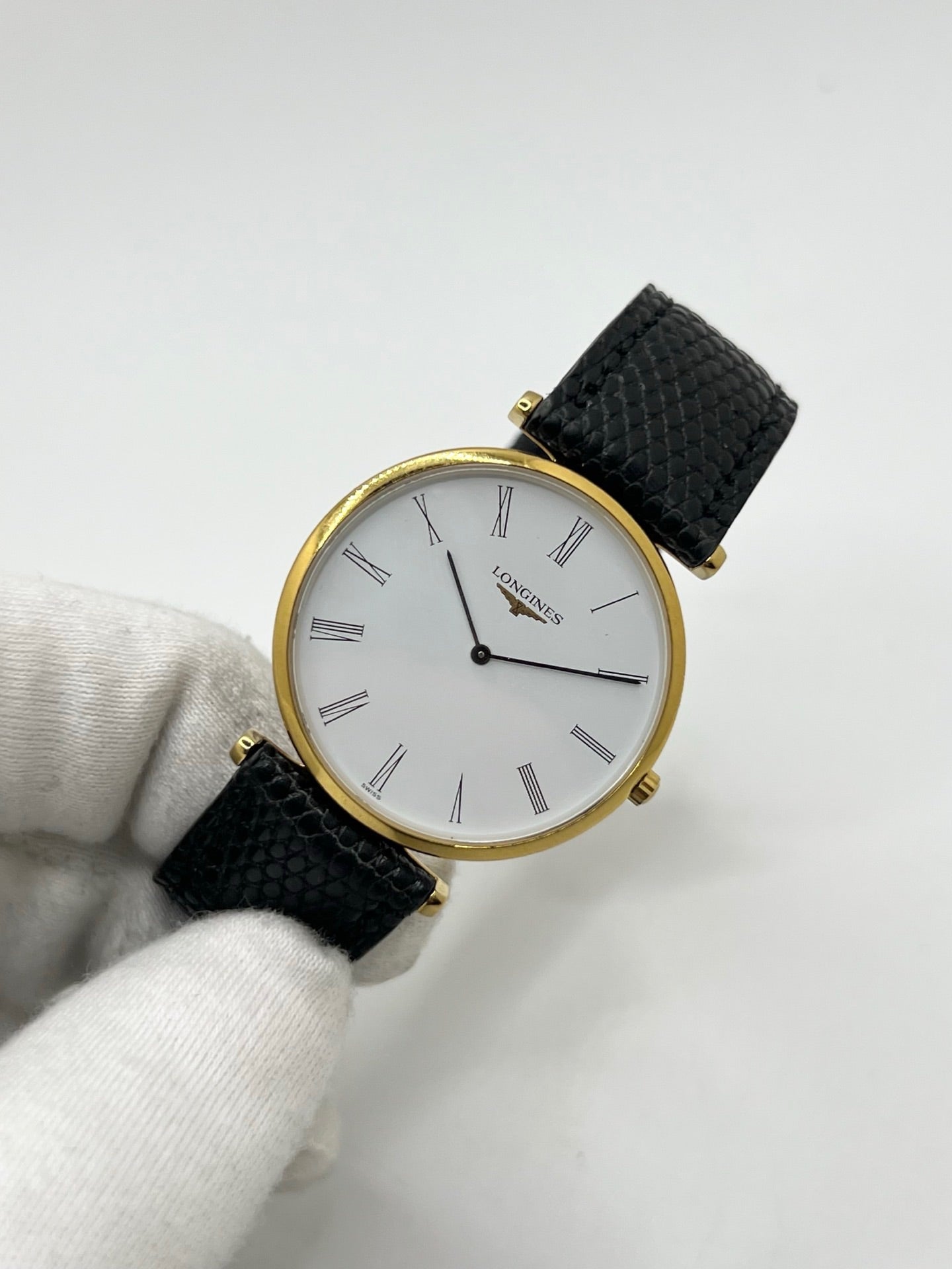Montre Longines La Grande Classique référence L4.709.2 en plaqué or avec boîtier de 33 mm, cadran blanc à chiffres romains et verre saphir. Ce modèle à mouvement quartz est équipé d’un bracelet en cuir noir avec boucle ardillon en acier. Son design élégant et intemporel en fait une montre de ville raffinée, adaptée aussi bien aux hommes qu’aux amateurs de montres classiques. Pièce d’occasion en très bon état, révisée et prête à être portée.
