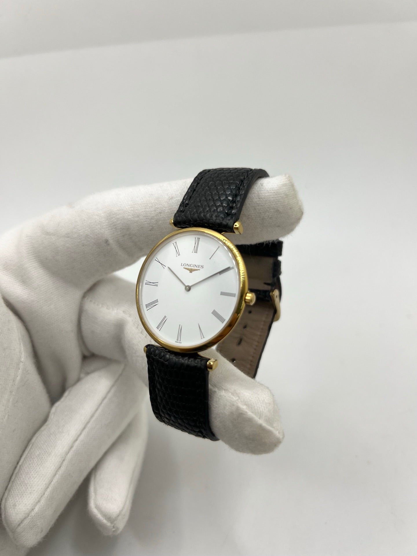 Montre Longines La Grande Classique référence L4.709.2 en plaqué or avec boîtier de 33 mm, cadran blanc à chiffres romains et verre saphir. Ce modèle à mouvement quartz est équipé d’un bracelet en cuir noir avec boucle ardillon en acier. Son design élégant et intemporel en fait une montre de ville raffinée, adaptée aussi bien aux hommes qu’aux amateurs de montres classiques. Pièce d’occasion en très bon état, révisée et prête à être portée.
