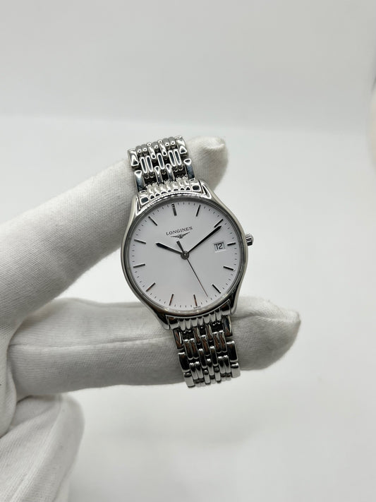Montre Longines Lyre L43594126 en acier, équipée d’un mouvement à quartz et d’un boîtier de 32 mm. Son cadran blanc élégant est protégé par un verre saphir, offrant une bonne résistance aux rayures. Cette montre Longines Lyre se distingue par son design classique et intemporel, idéal pour accompagner toutes les occasions. Son bracelet en acier assorti, doté d’une boucle déployante double, apporte une finition harmonieuse et raffinée. Modèle de 2018, livré avec son coffret et ses papiers d’origine.