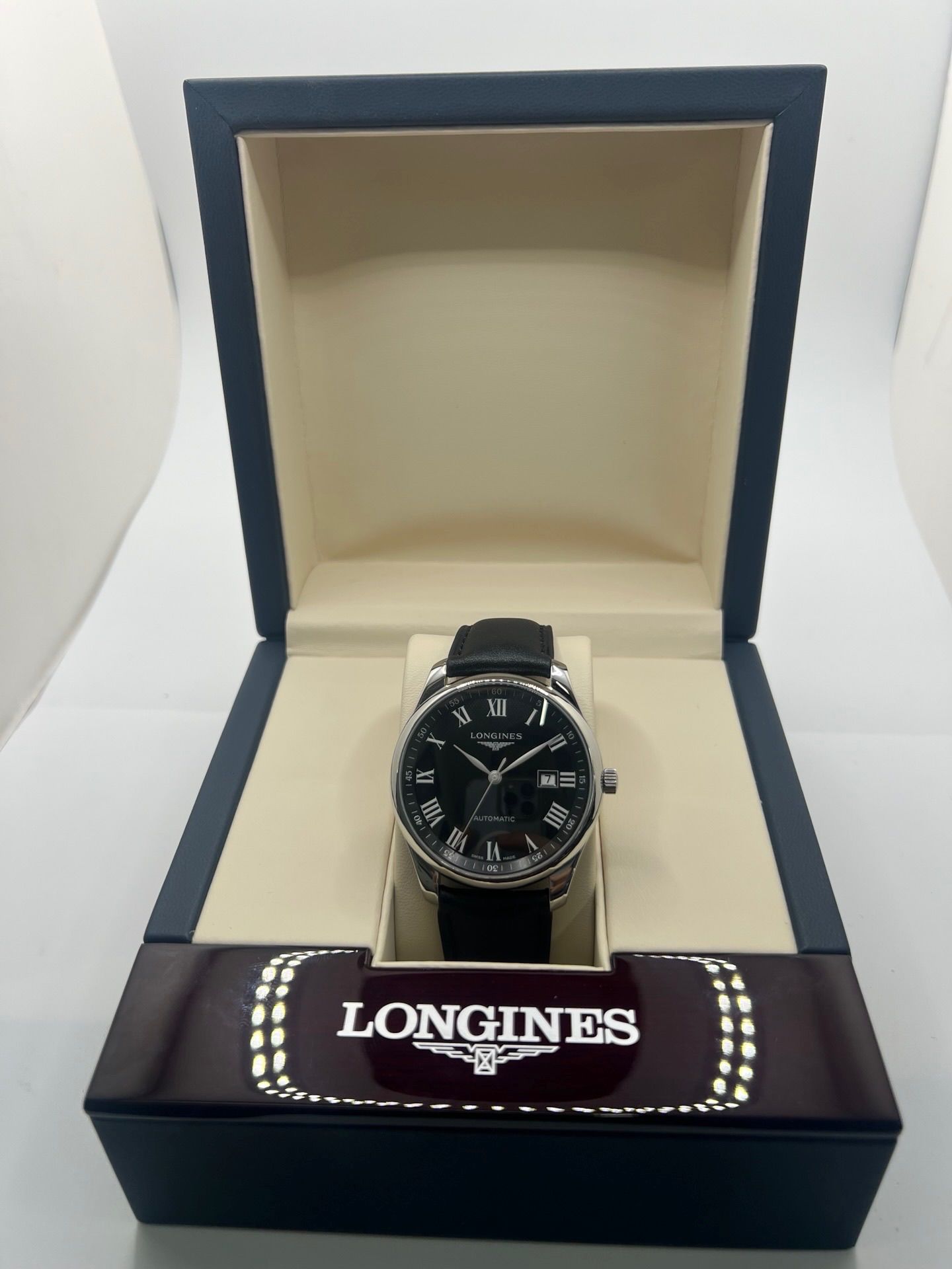 Montre automatique Longines Master Collection L2.893.4.51.6 en acier 42 mm, équipée d’un cadran noir épuré, d’un verre saphir et d’un bracelet en cuir noir. Modèle élégant avec fonction date, en très bon état d’occasion, présentant de légères micro-rayures, livré avec coffret d’origine.