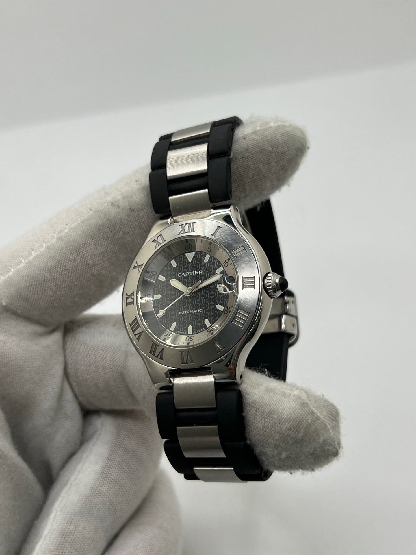 Montre Cartier 21 Must de Cartier Autoscaph automatique en acier, modèle homme ou unisexe avec boîtier de 37 mm et cadran noir à chiffres romains. Ce modèle d’occasion en très bon état dispose d’un verre saphir, d’une étanchéité de 10 ATM et d’une fonction date. Son bracelet en caoutchouc noir avec boucle en acier complète son style sportif et élégant. Une montre Cartier 21 Must Autoscaph au design iconique, idéale pour les amateurs de montres de luxe.