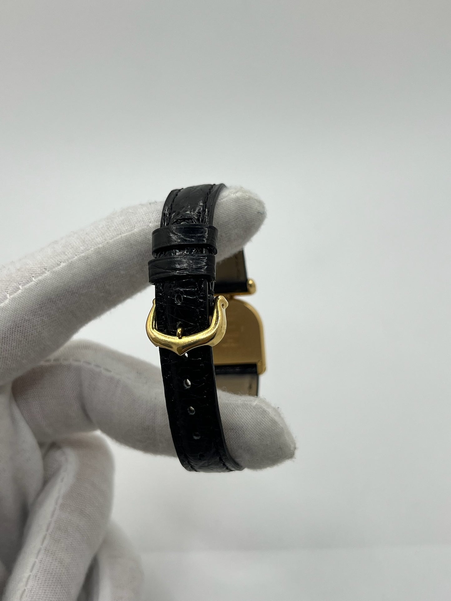 Montre Cartier modèle Calandre pour femme élégante en or jaune avec boîtier rectangulaire de 18 x 26 mm, lignes raffinées et design iconique des années 1980. Cadran blanc lumineux orné de chiffres romains noirs, protégé par un verre minéral. Mouvement à quartz assurant une lecture précise de l’heure. Bracelet en cuir de crocodile noir apportant une touche sophistiquée, équipé d’une boucle ardillon en acier. Modèle vintage en très bon état, présentant de légères micro-rayures superficielles liées à l’âge.